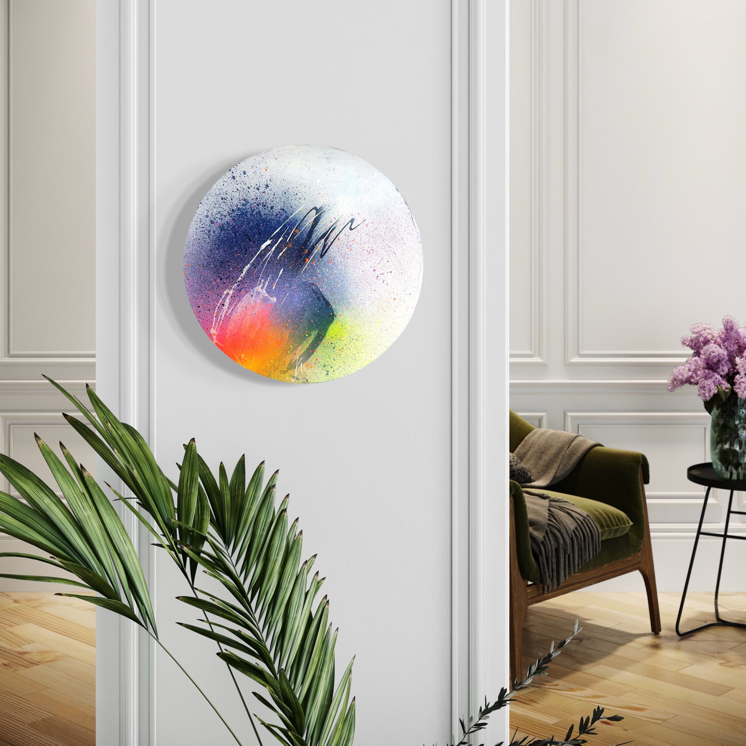 Kate Mayer's "Right Here, Right Now" painting adds vibrancy to a white wall beside a chair and plant.