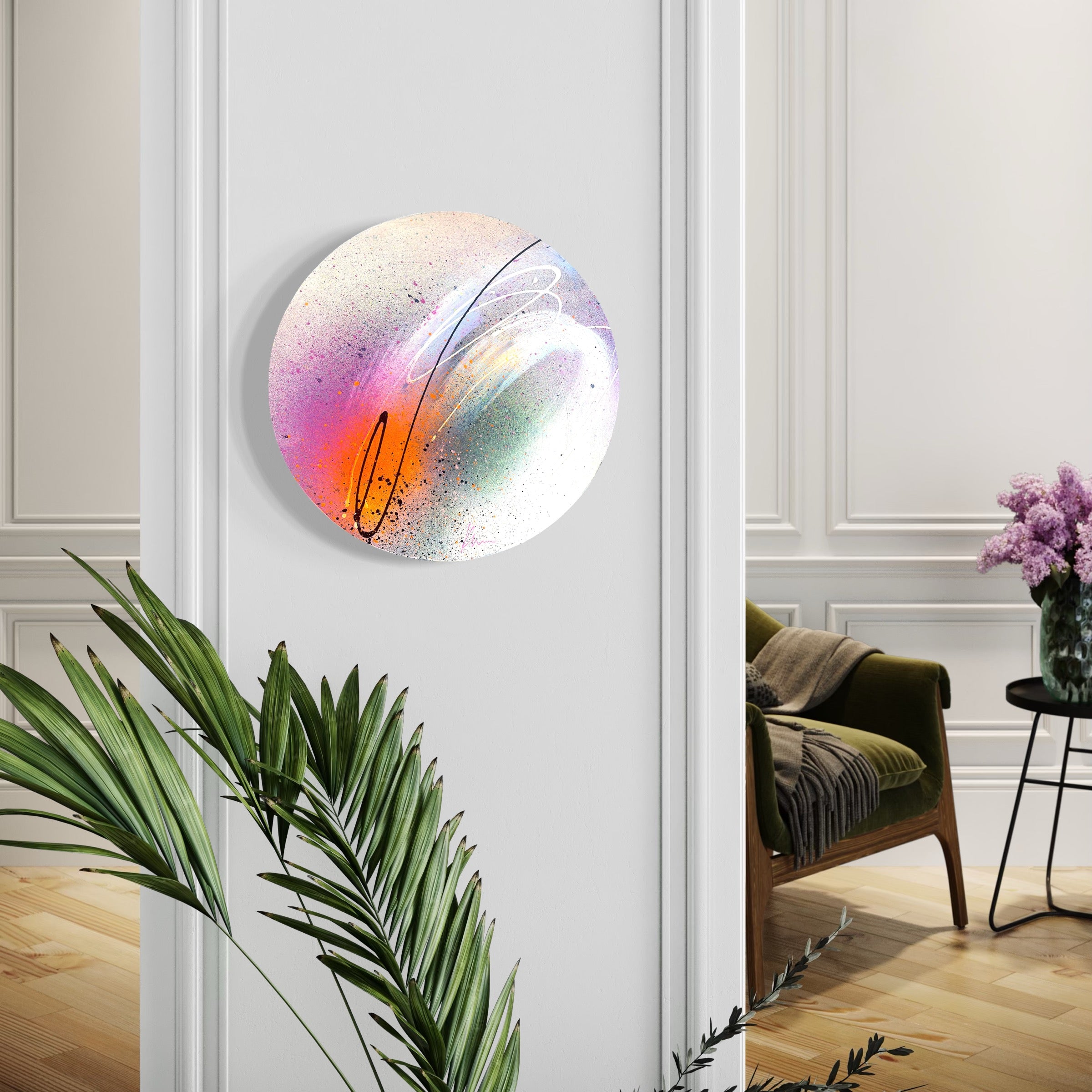 The painting "In This Moment" by Kate Mayer, featuring colorful swirls, is beautifully framed by greenery and purple flowers.