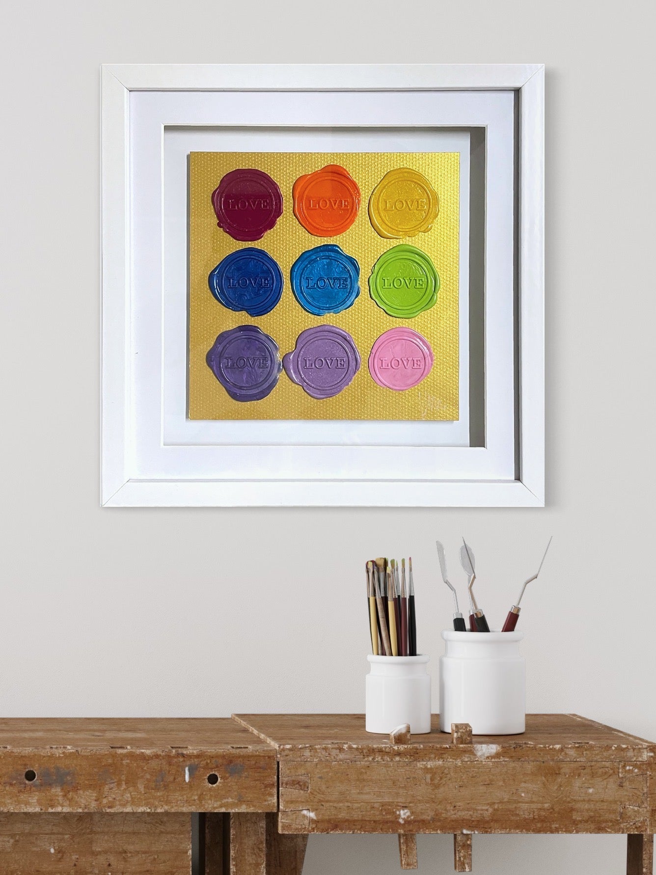 Kate Mayer’s Sealed Intention - Love is Love art features “LOVE” in wax seals, adding charm to any rustic desk.