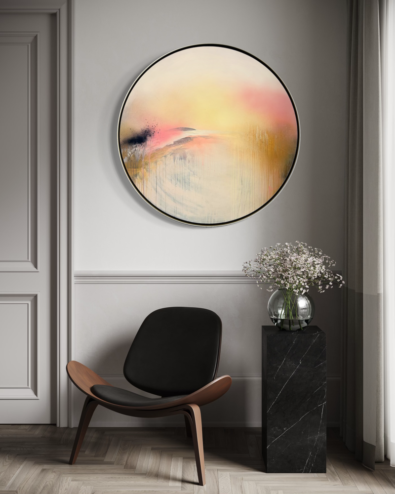 Modern room with a black chair, “Shadows” by Kate Mayer in a metal float frame, and white flowers on a black pedestal.