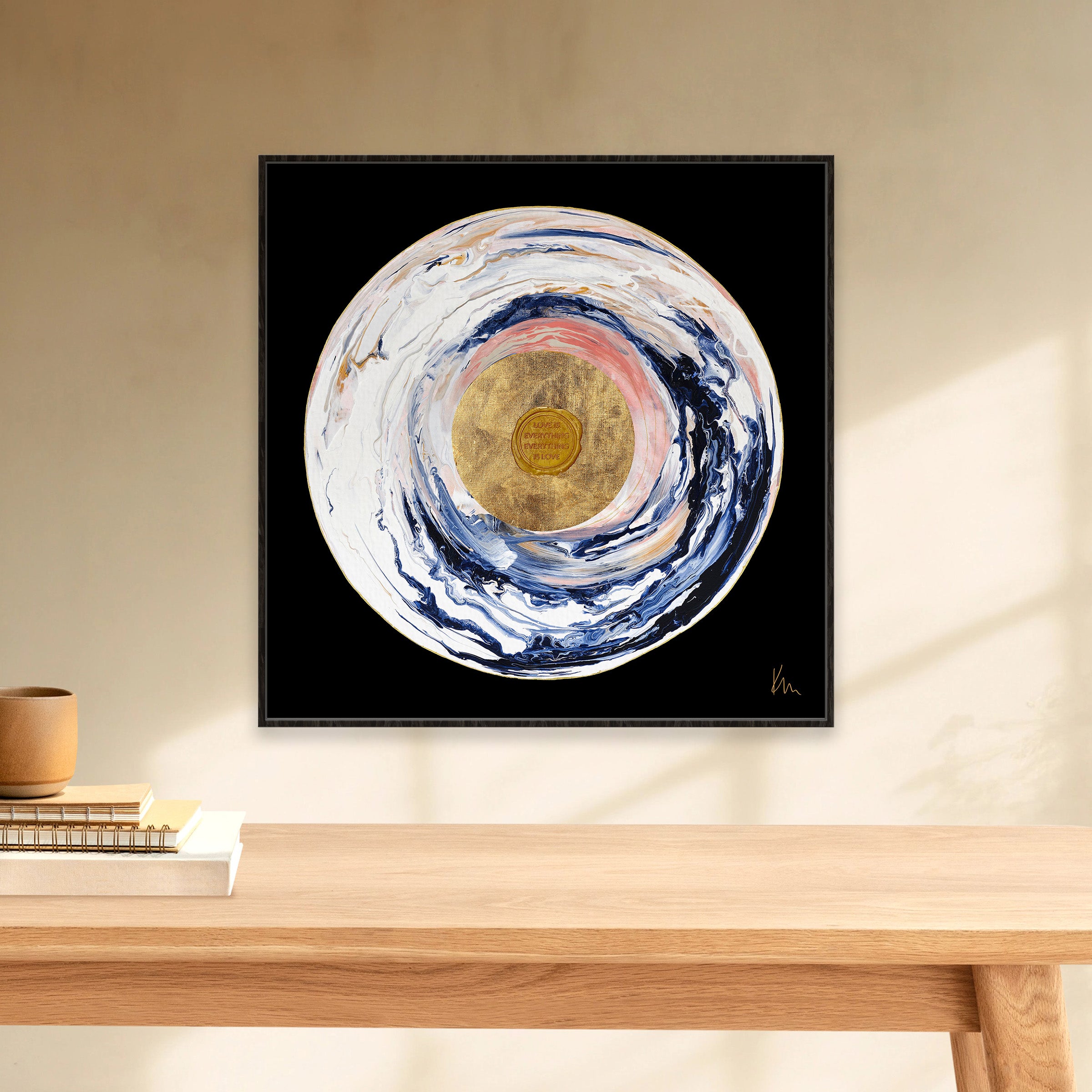The captivating painting "Love Sublime" by Kate Mayer features mesmerizing abstract circular swirls of blue, pink, and gold set against a black background. Elegantly framed, it transforms any beige wall with a touch of intrigue.