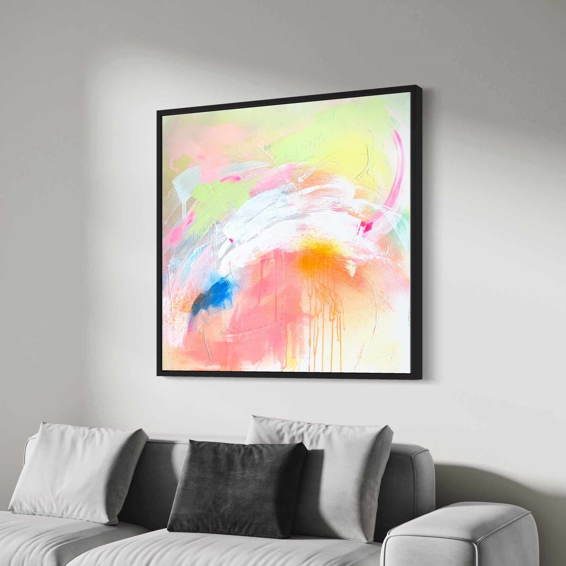 Kate Mayer's Pure Joy - Original Painting, featuring vibrant pastel colors created with acrylic and spray paint on canvas, adorns the wall above a light gray couch with white and gray cushions. It is elegantly framed in a black wooden float frame.