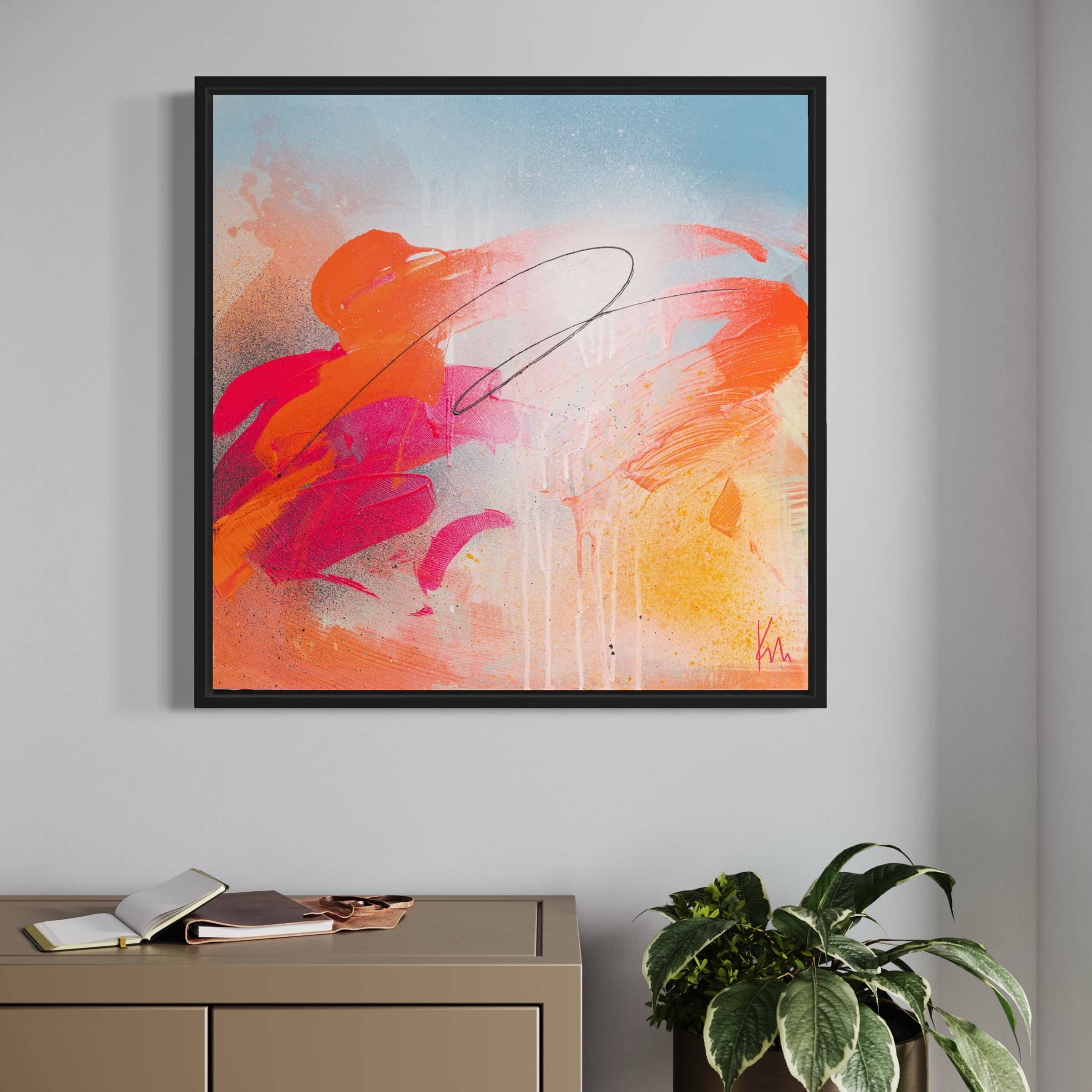 The "Dance With Me" original painting by Kate Mayer, featuring vibrant swirls of orange, pink, and red hues, graces the wall above a console table adorned with books and a plant.
