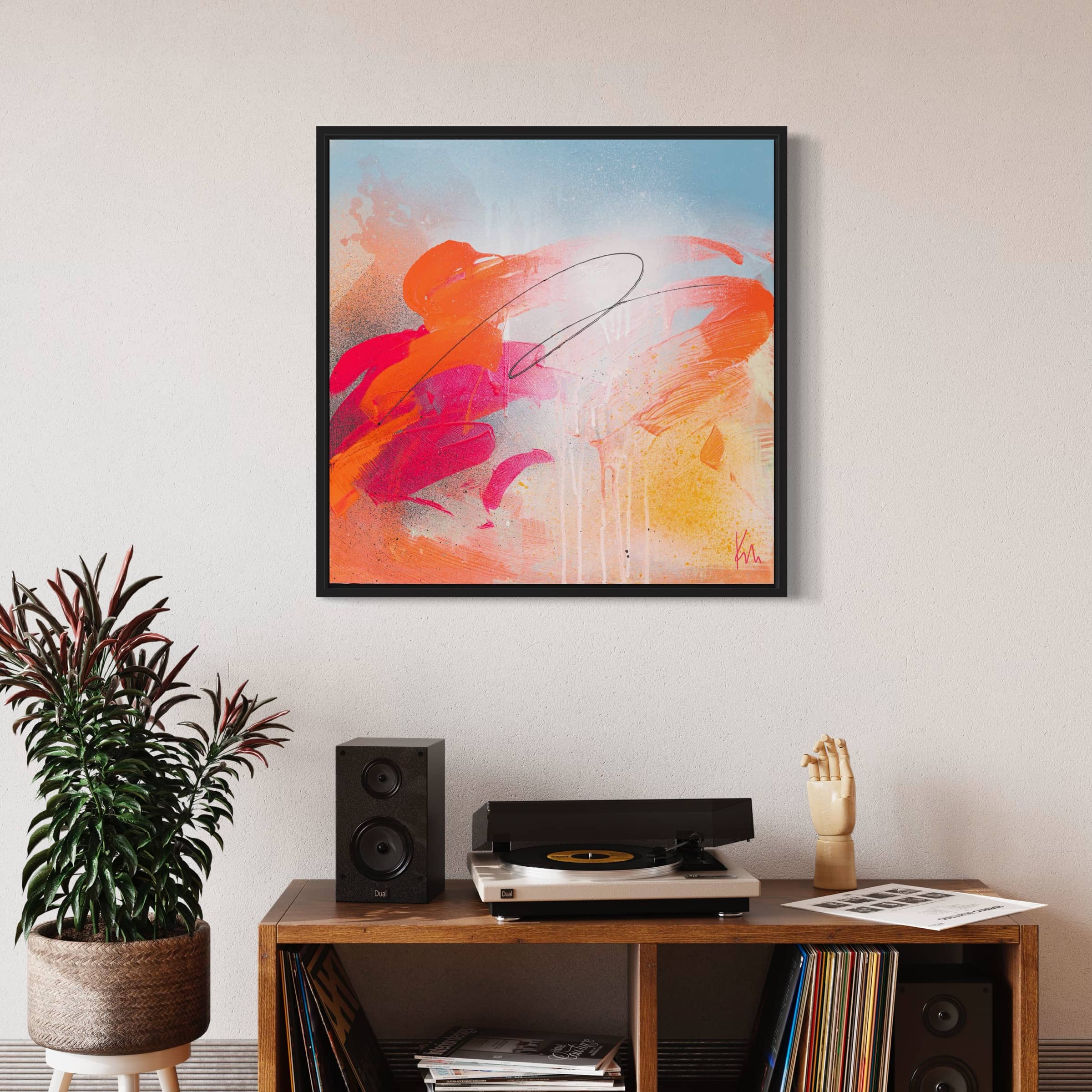 Dance With Me," an original painting by Kate Mayer, showcases dynamic orange and pink acrylic strokes on canvas. It's beautifully displayed above a record player and speakers on a wooden shelf, infusing the space with artistic elegance.