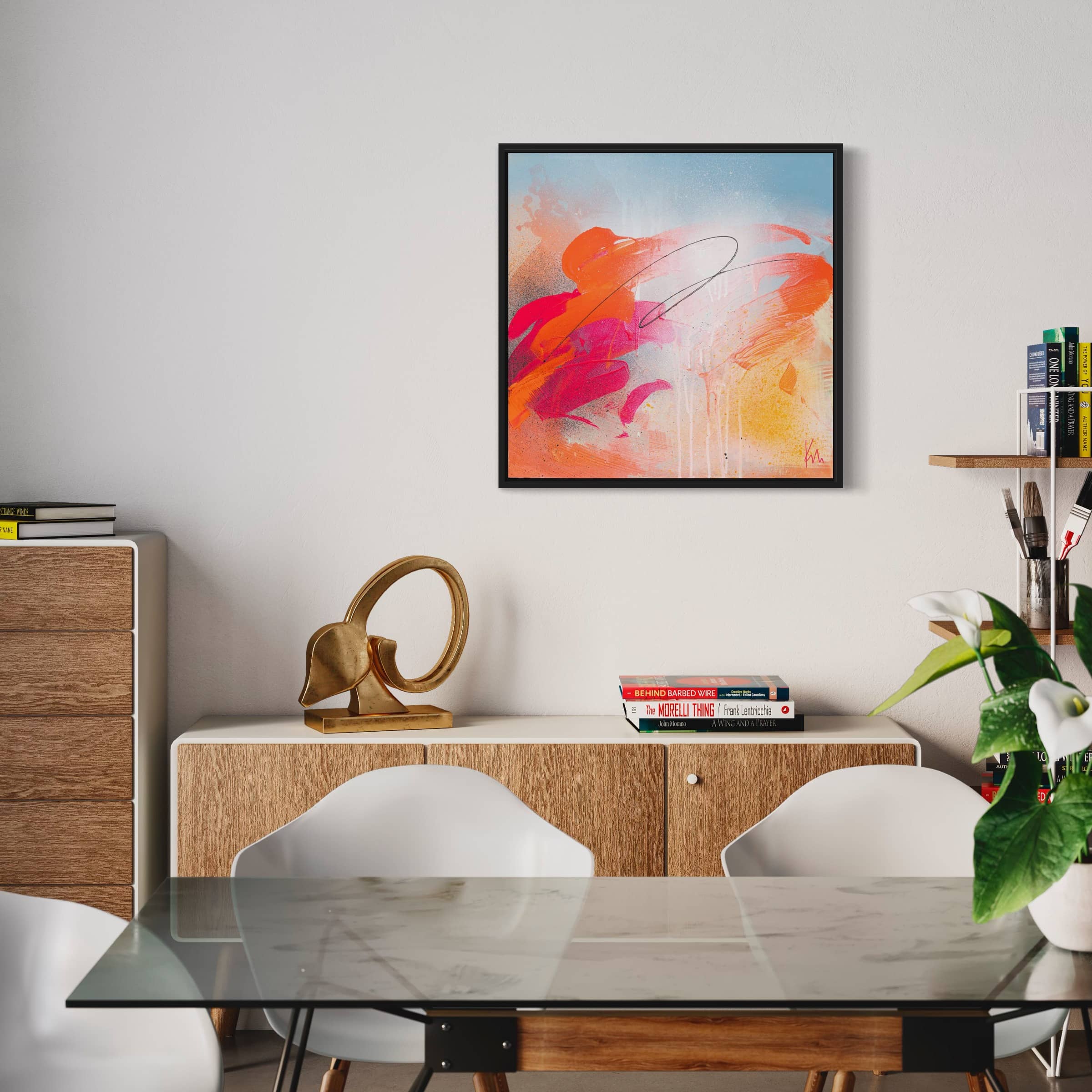 A modern dining room showcasing the "Dance With Me" original painting by Kate Mayer, complemented by white chairs, a wooden sideboard, books, and a decorative sculpture.