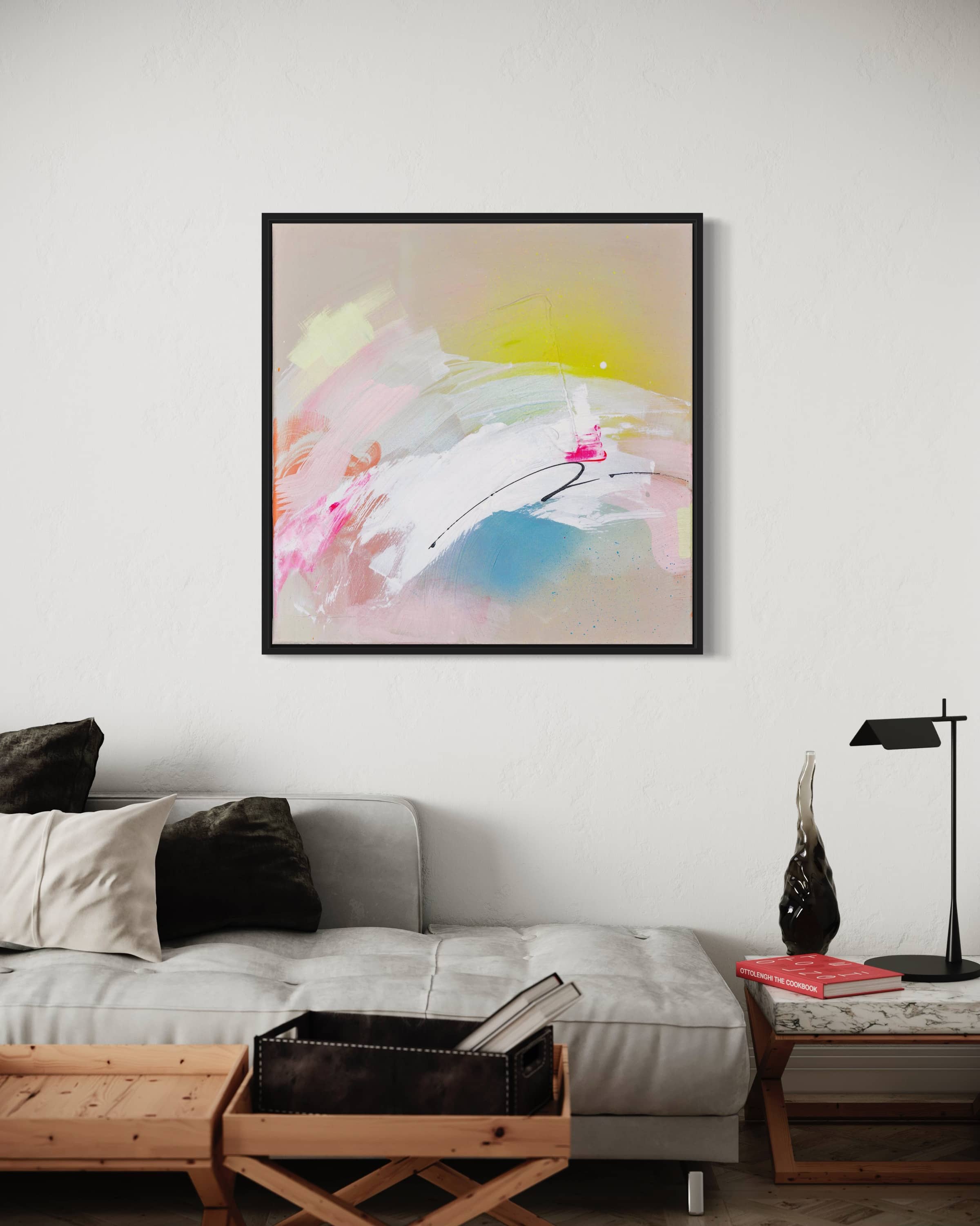 The Miami Beach - Original Painting by Kate Mayer showcases pink, white, and yellow brushstrokes created with acrylic and spray paint. It's elegantly displayed in a sleek black frame above a modern sofa in a minimalist room.