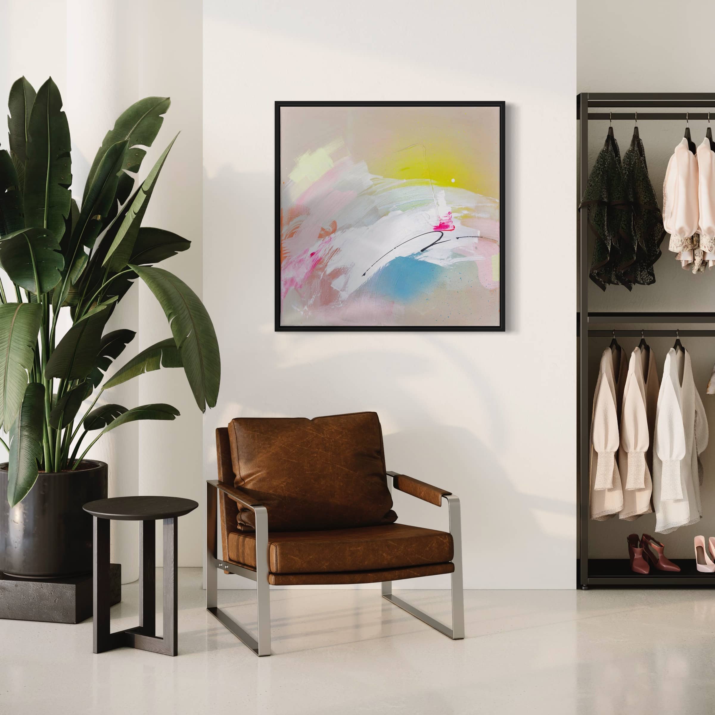 A modern room featuring a leather chair and "Miami Beach," an original painting by Kate Mayer, crafted with acrylic and spray paint. Complemented by a side table, a large plant, and a sleek clothing rack, the space exudes contemporary charm.