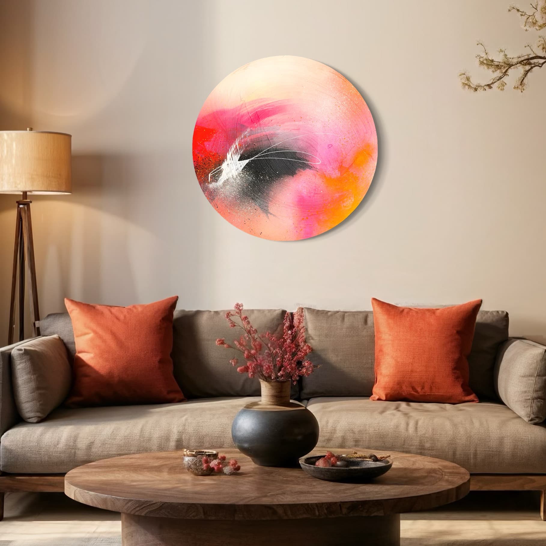 A cozy living room with a brown sofa, orange pillows, Kate Mayer’s "Set The World On Fire" painting, and a wooden table with vases.