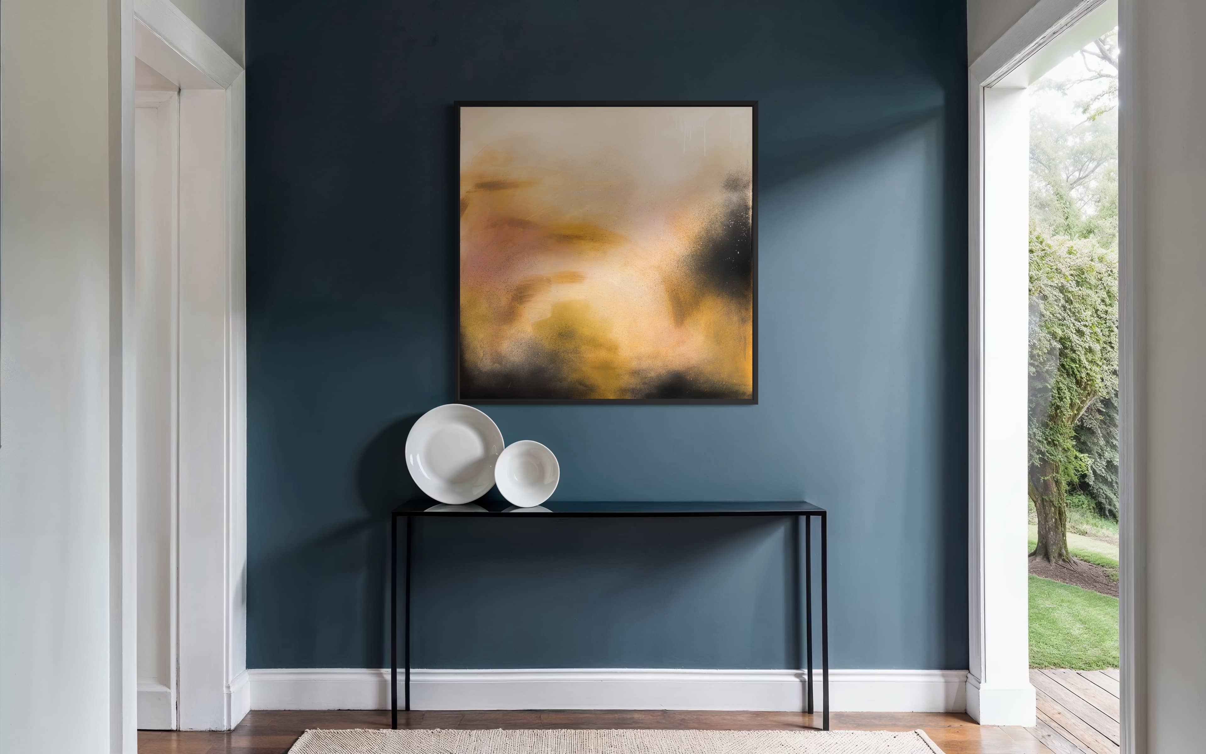 A modern entryway featuring "Everything In Its Right Place" by Kate Mayer above a black console and white bowls.