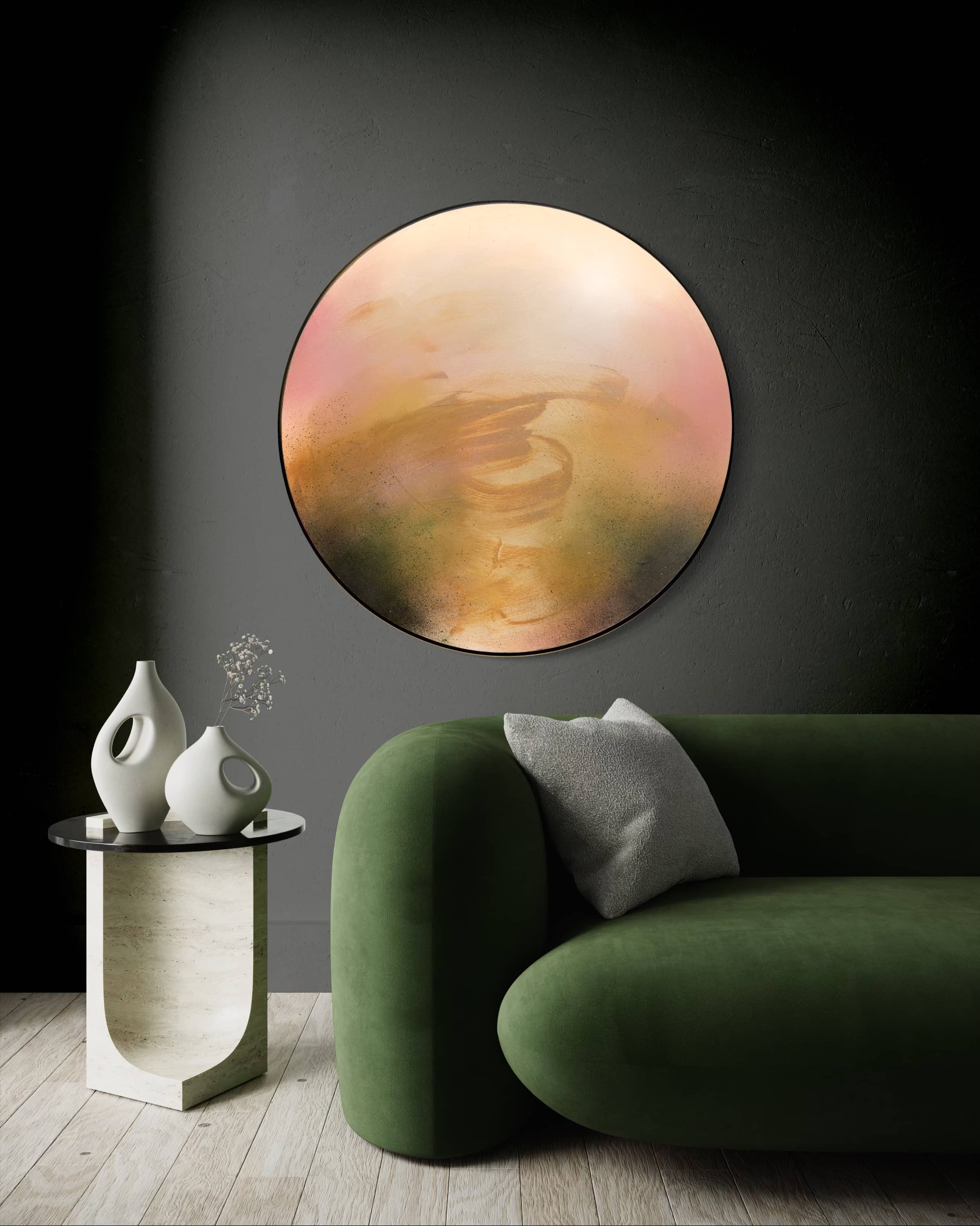The Kindling by Kate Mayer, a circular plywood art in a metal float frame, hangs above a green sofa and white vases.