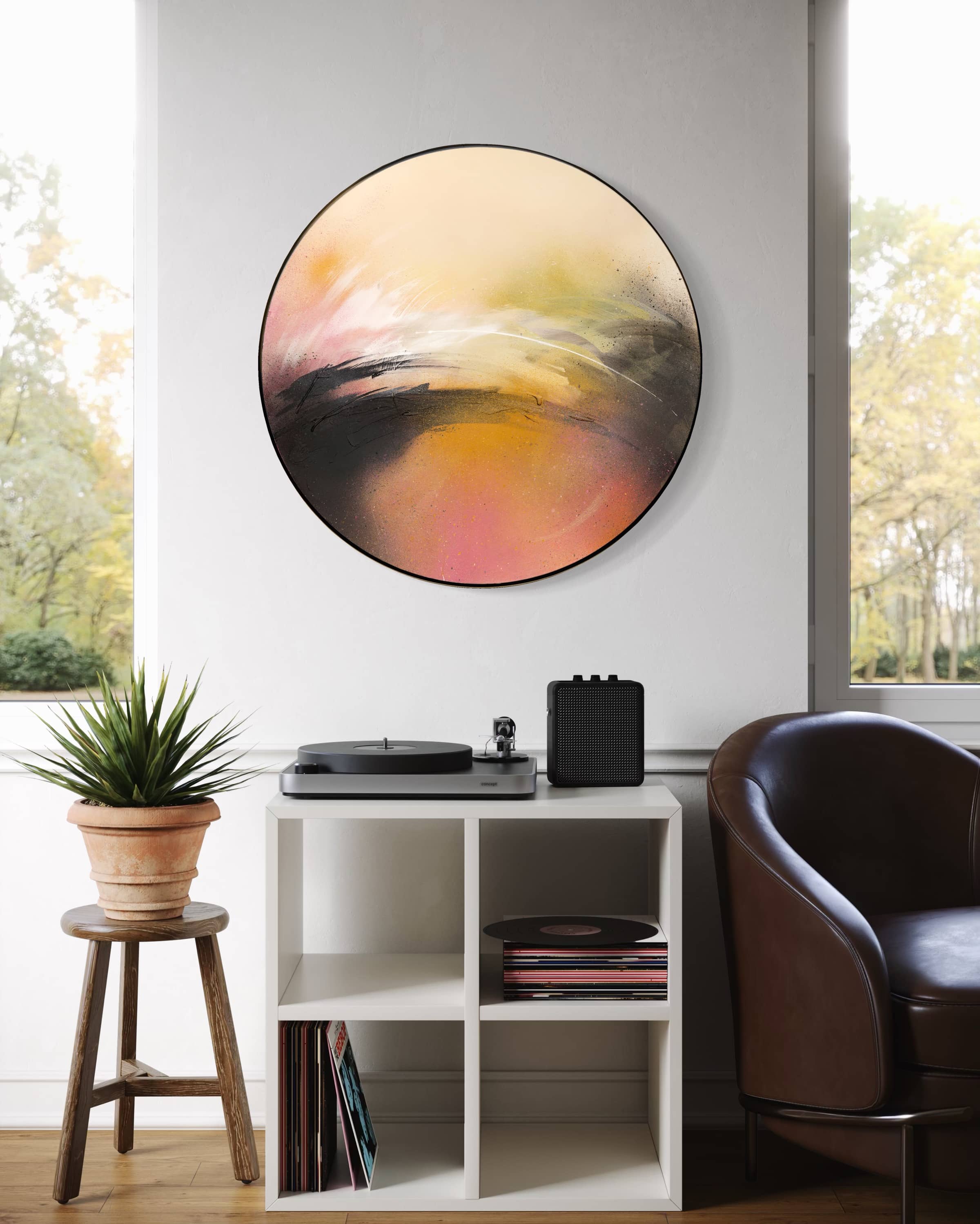 Kate Mayer's "One Day Like This" hangs above a shelf with a record player, speaker, plant, and brown leather chair.