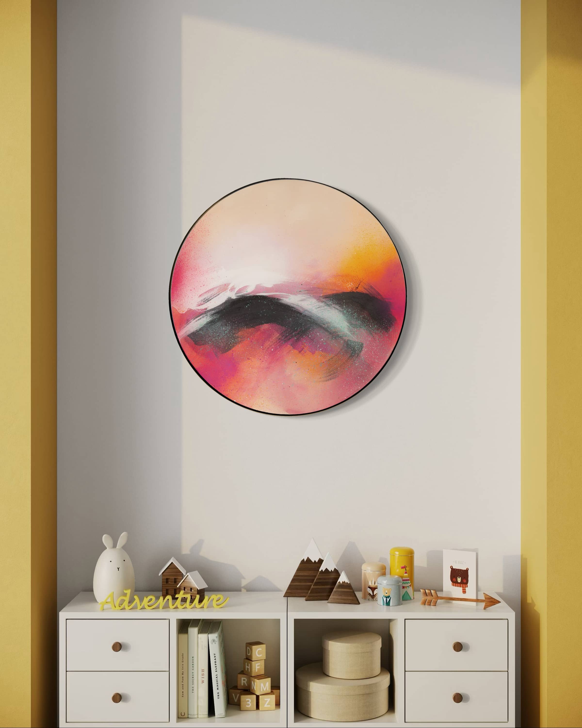 The round abstract painting "Optimistic" by Kate Mayer in a handmade metal float frame hangs above shelves with toys and books.