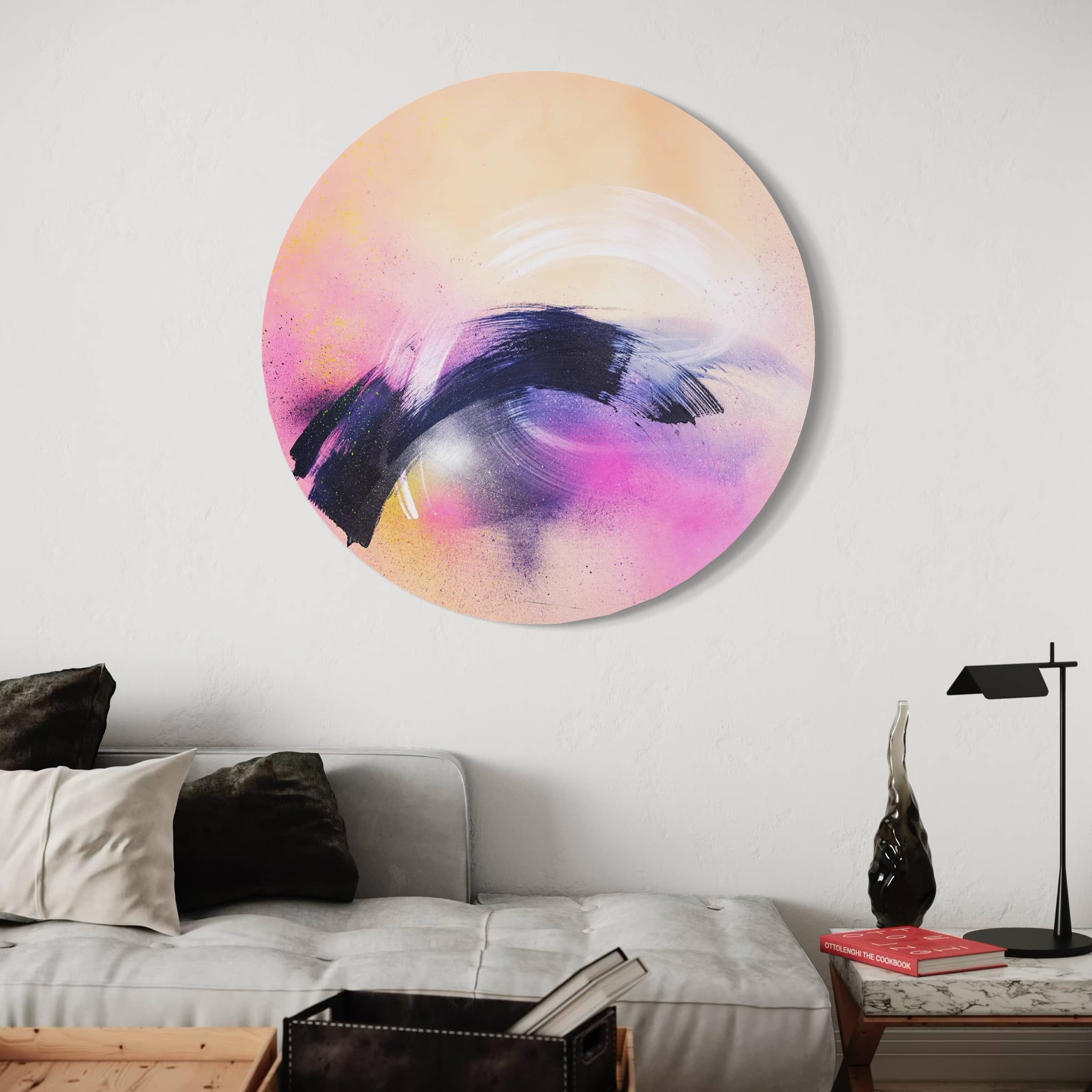 Breathe In The Air" by Kate Mayer: Acrylic on circular panel with pink, black, cream swirls; above a couch with a lamp.