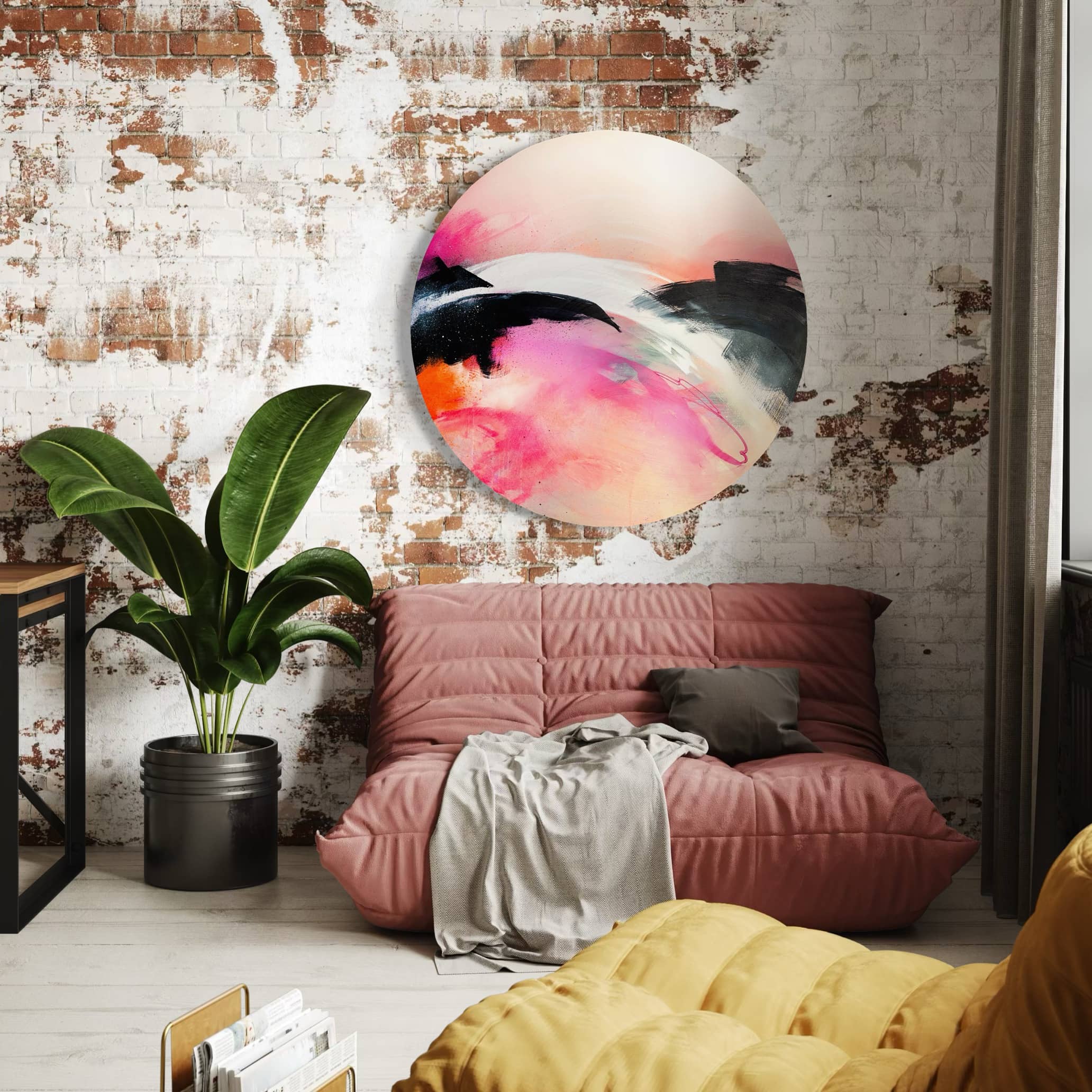 Cozy room with a rust-colored couch, banana plant, and Kate Mayer's "It's A New Dawn" painting in a metal frame on brick wall.