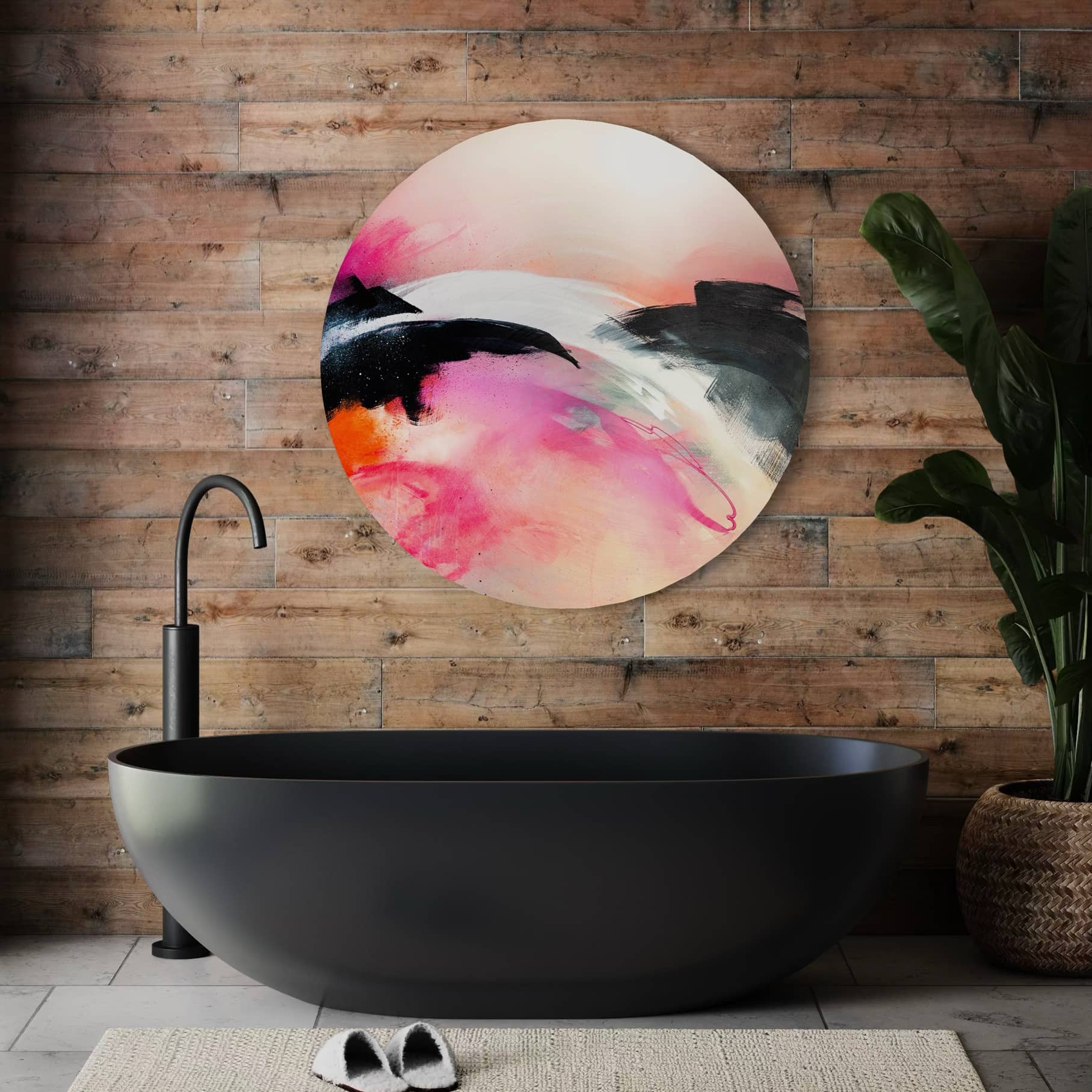 A modern bathroom features a black tub, wooden wall, Kate Mayer's "It's A New Dawn" art, and a potted plant.