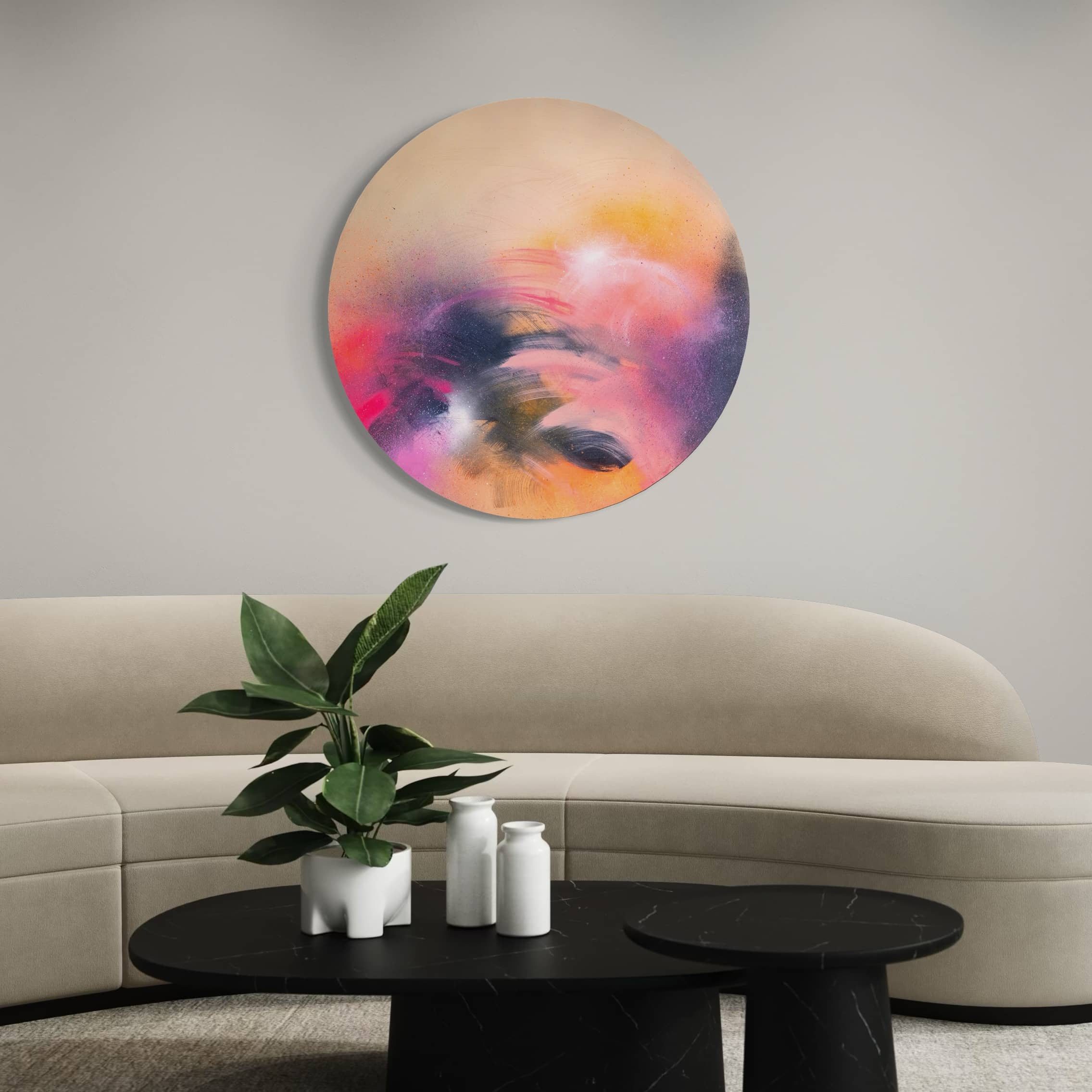 A Star is Born" by Kate Mayer above curved beige sofa, with plant and candles on round black coffee table.