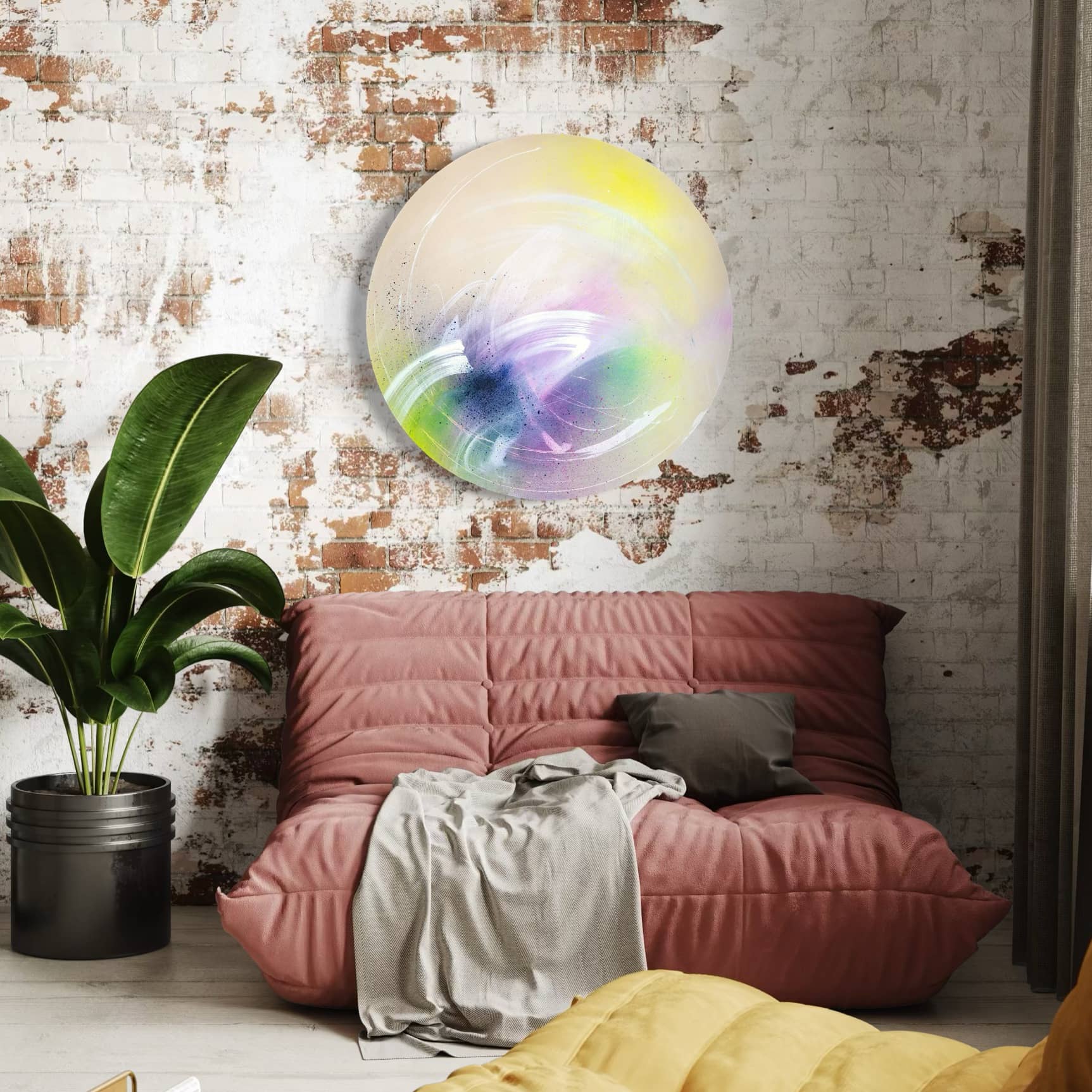 A cozy room with a pink sofa, gray pillow, plant, and Kate Mayer's "I Believe In Miracles" painting on the brick wall.