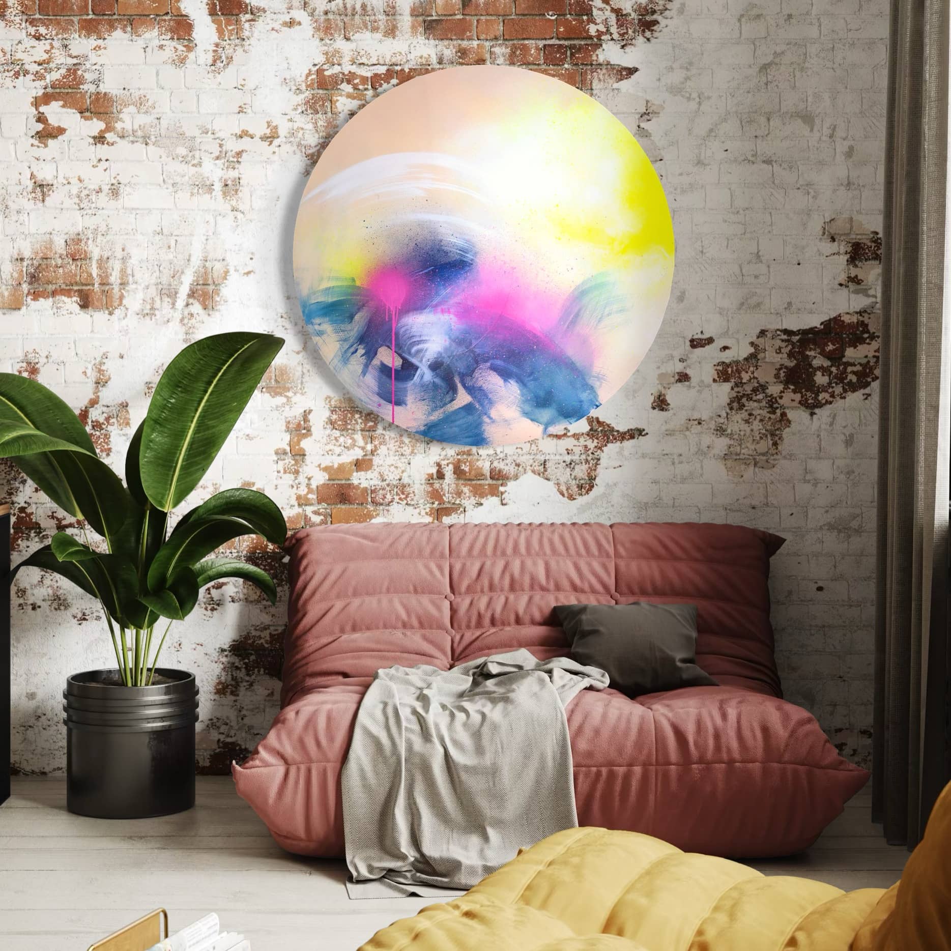 A cozy room with a pink futon, potted plant, and Kate Mayer's "Rolling In The Deep" in a handmade frame on a brick wall.