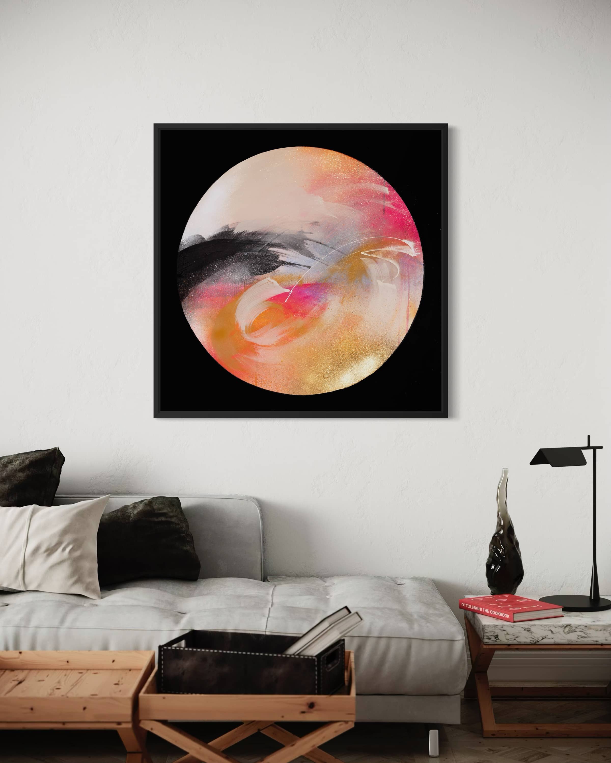 “Passion” by Kate Mayer hangs above a modern sofa in a minimalist living room with neutral decor.