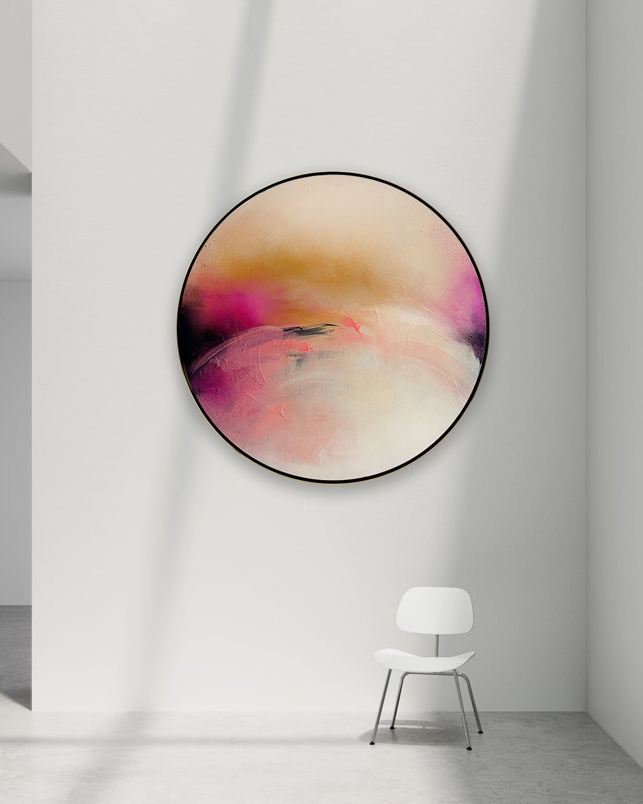 Abstract circular painting, Unfinished Sympathy, by Kate Mayer with soft pink, peach, cream, and magenta tones, displayed on a white wall in a minimalist room with a white chair below.