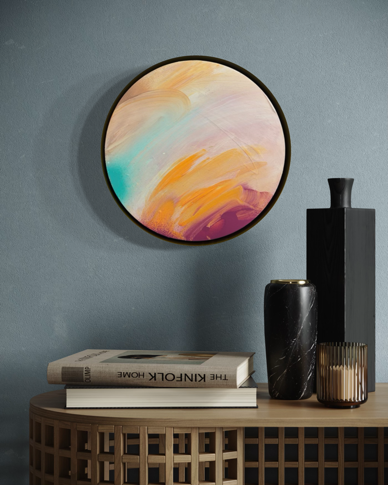 Good Times by Kate Mayer: a round abstract painting in a handmade metal float frame on a blue-gray wall above decor.