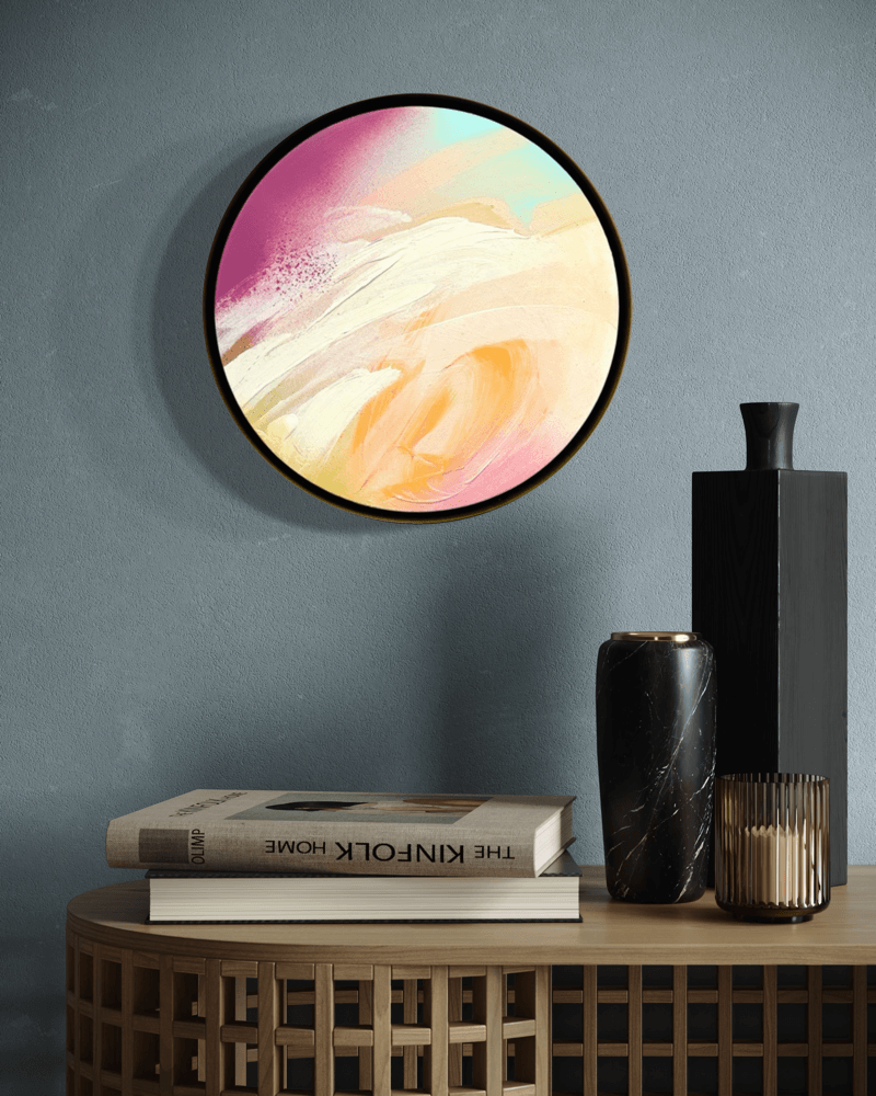 I Smile by Kate Mayer: a round acrylic painting on plywood in a handmade metal float frame, shown above books and vases.