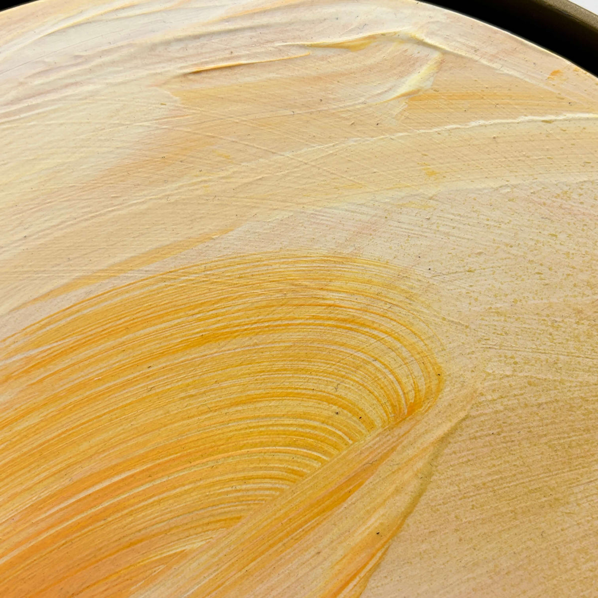 Closeup of “Lovely Day” by Kate Mayer: orange and yellow acrylic swirls on plywood, visible brush strokes.
