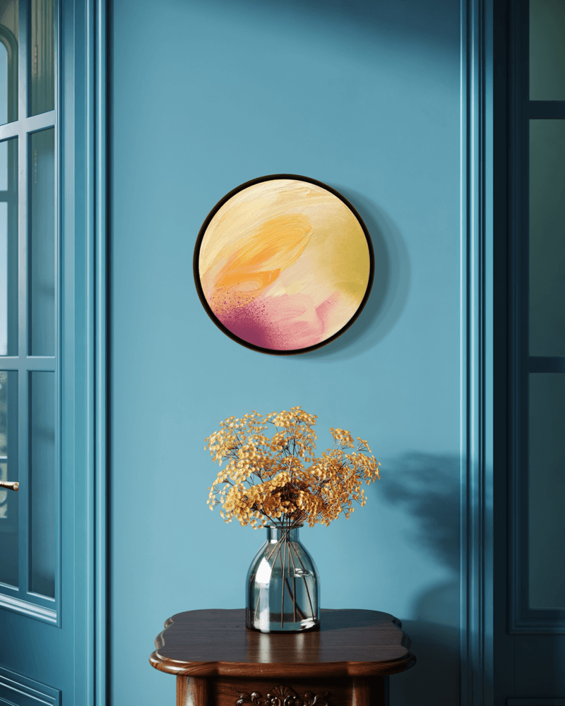 ‘Lovely Day’ by Kate Mayer in a metal float frame and dried flowers decorate a wood table by a blue wall.