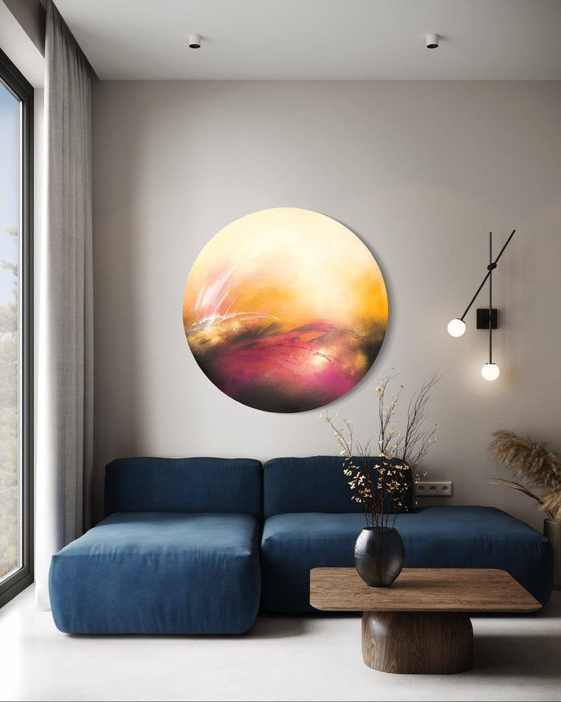 Modern living room with a blue sofa, Kate Mayer's "It’s Alright, I Feel It" artwork, wooden table, and vase.