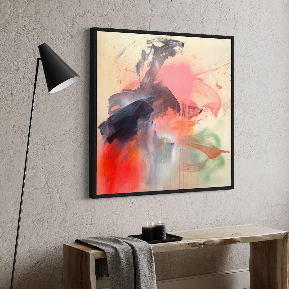 The "Fire And Ice" original painting by Kate Mayer features bold red, pink, and black brushstrokes on a textured wall, complemented by the glow of a modern lamp and the charm of a wooden table.