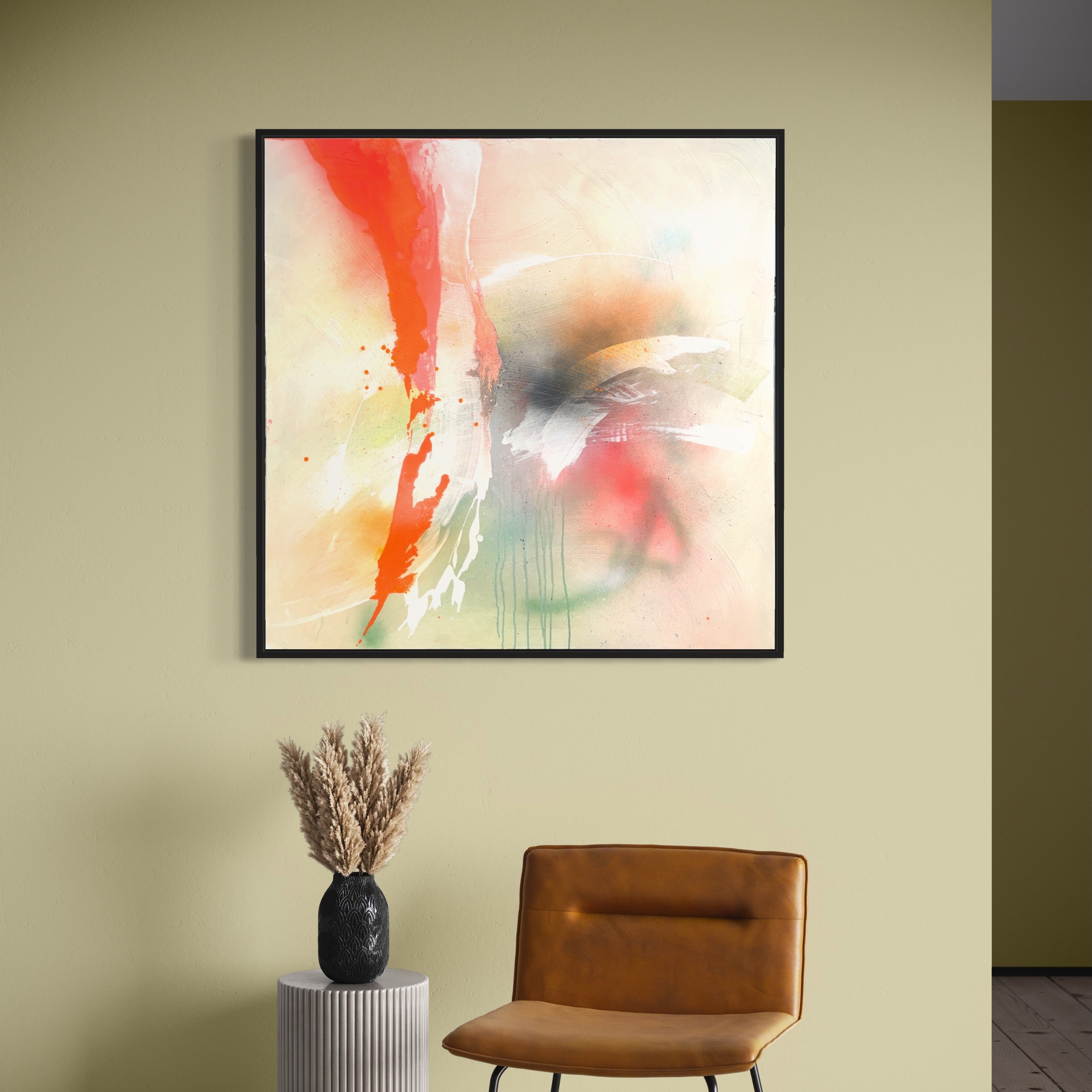 Rainbow Falls - Original Painting by Kate Mayer, featuring dynamic splashes of red, green, and black hues, is artistically displayed on a light green wall. Encased in a sleek black wooden float frame, the artwork adds depth and intrigue to the space. Below it sits a brown chair accompanied by a vase of dried plants.