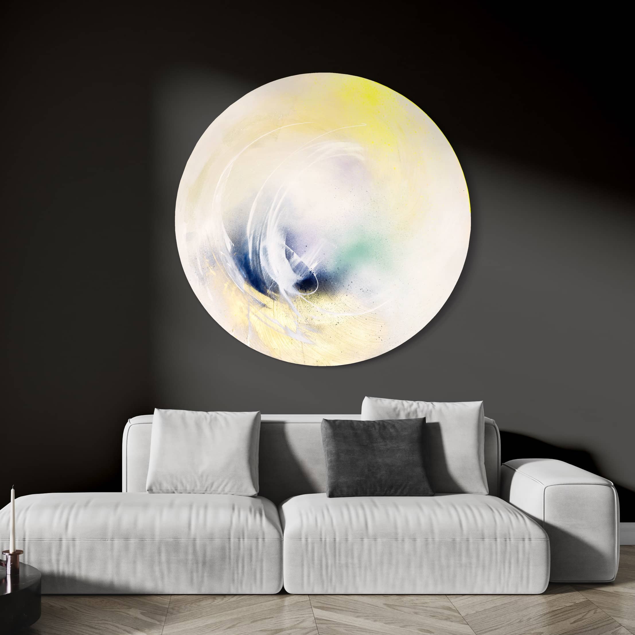 The original painting, "Let's Make This Moment Last" by Kate Mayer, showcasing swirling colors created with acrylic and spray paint, adorns a dark wall above a white sofa that is accented with a gray pillow.