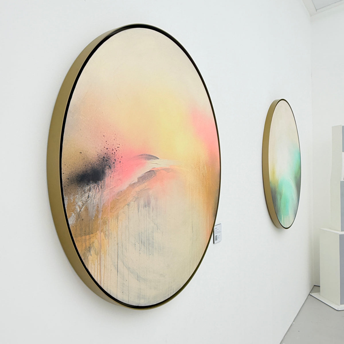 Shadows by Kate Mayer: two oval acrylics on plywood in handmade metal float frames shown on a white gallery wall.