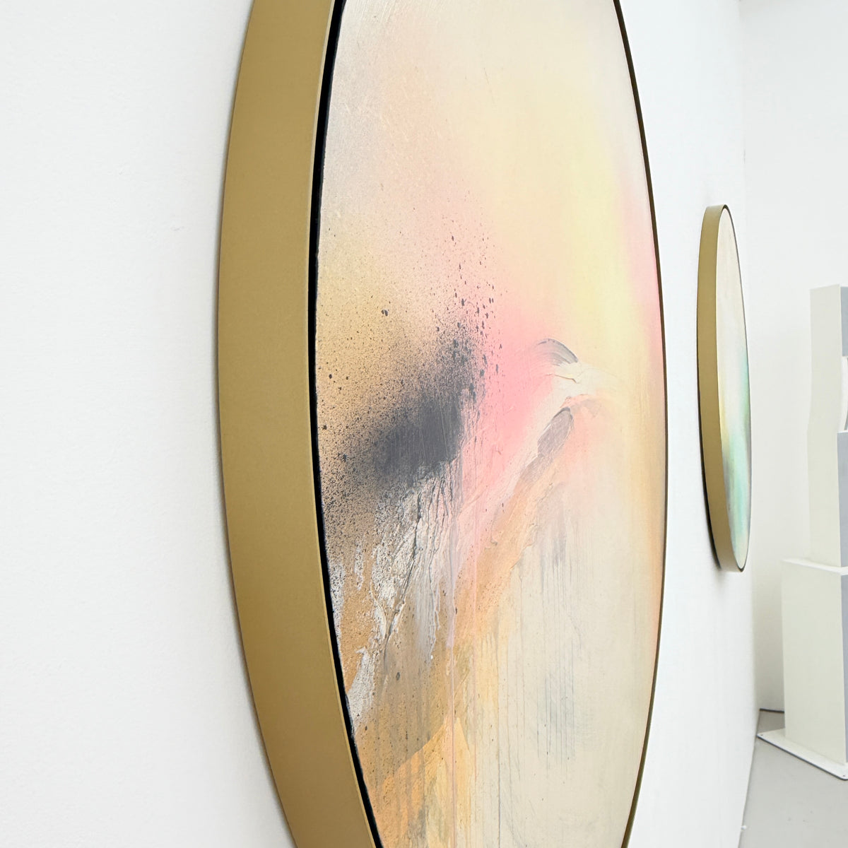 Shadows by Kate Mayer, oval abstract art with soft pastels in metal float frames, hangs on a white gallery wall.