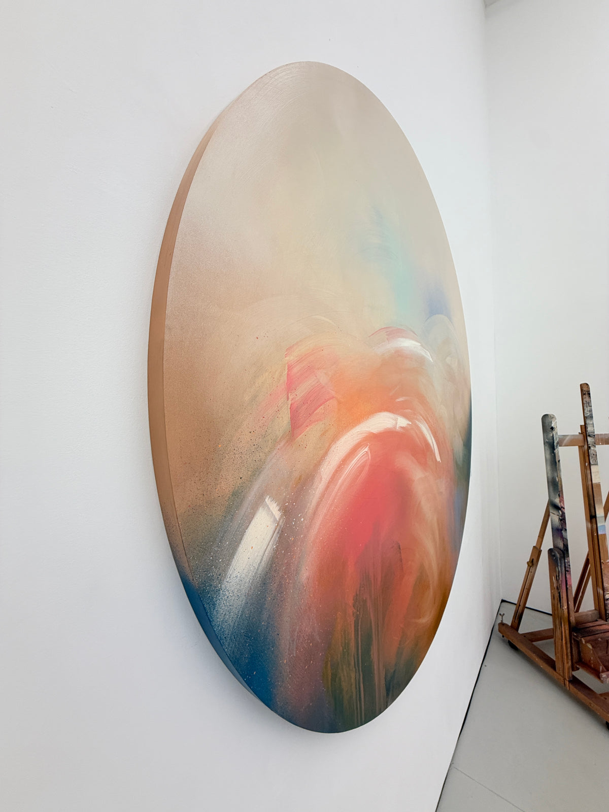 Count Your Blessings“ by Kate Mayer: round abstract art with soft hues, handmade metal float frame, easels behind.