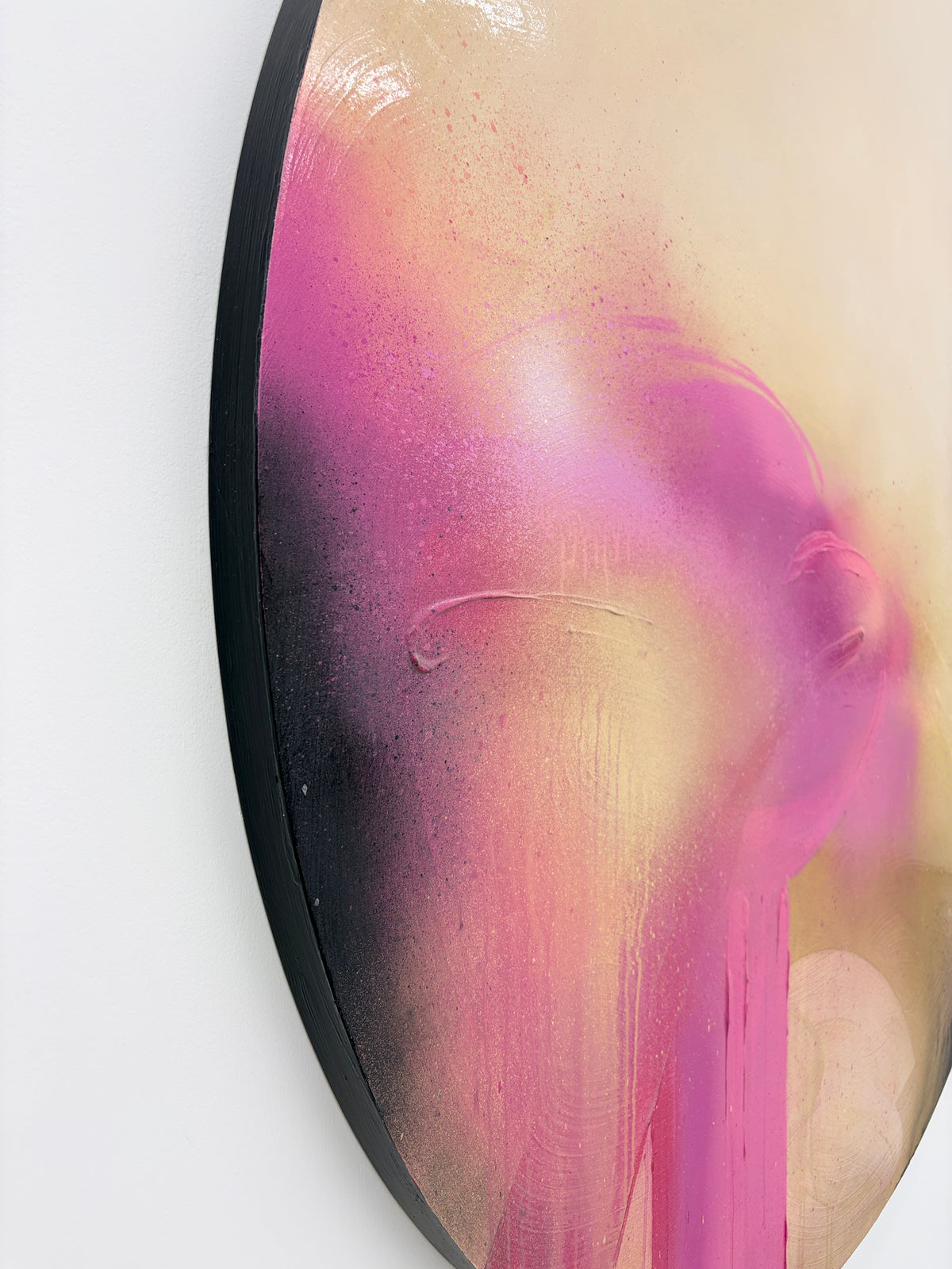 Afterglow“ by Kate Mayer: Circular abstract art with pink, gold, black spray paint, and diamond dust shimmer.
