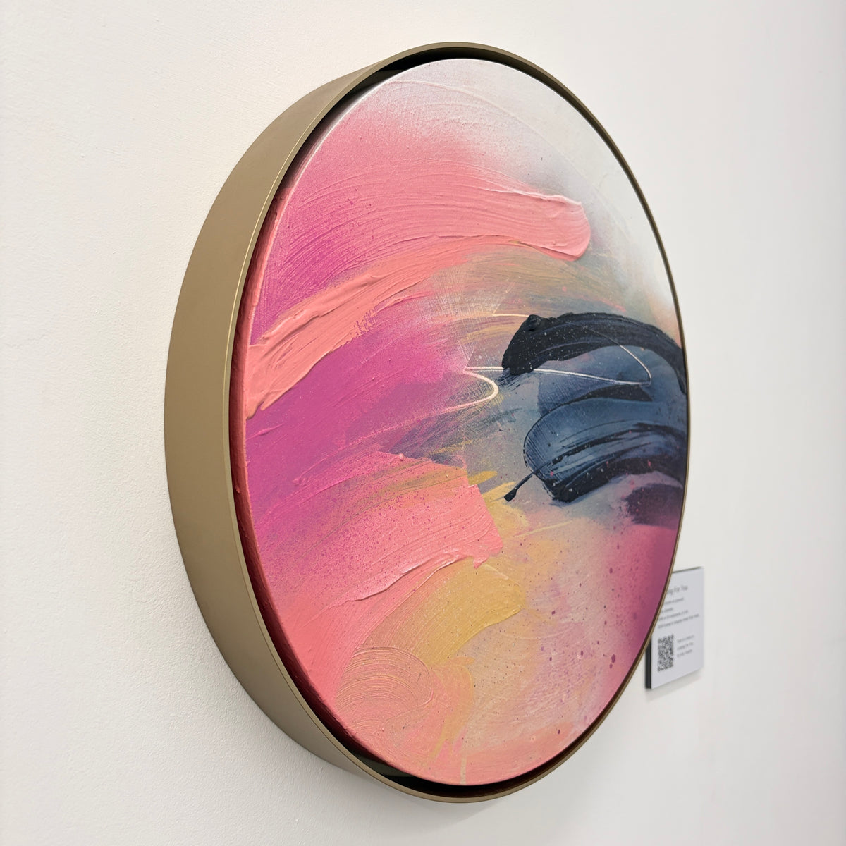 ‘Looking For You’ by Kate Mayer: round abstract in handmade metal frame, pink/yellow/blue, on white wall.