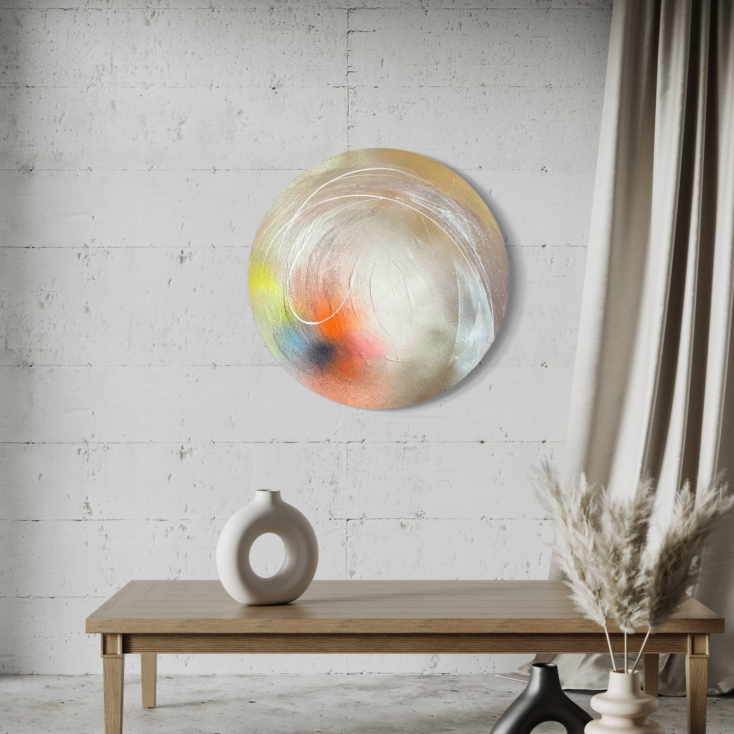 Modern living room with "The Time Is Now," an original abstract painting by Kate Mayer, a minimalist table featuring a white vase, and pampas grass near a light-gray curtain. The circular artwork shimmers subtly with acrylic diamond dust, adding a touch of elegance to the space.