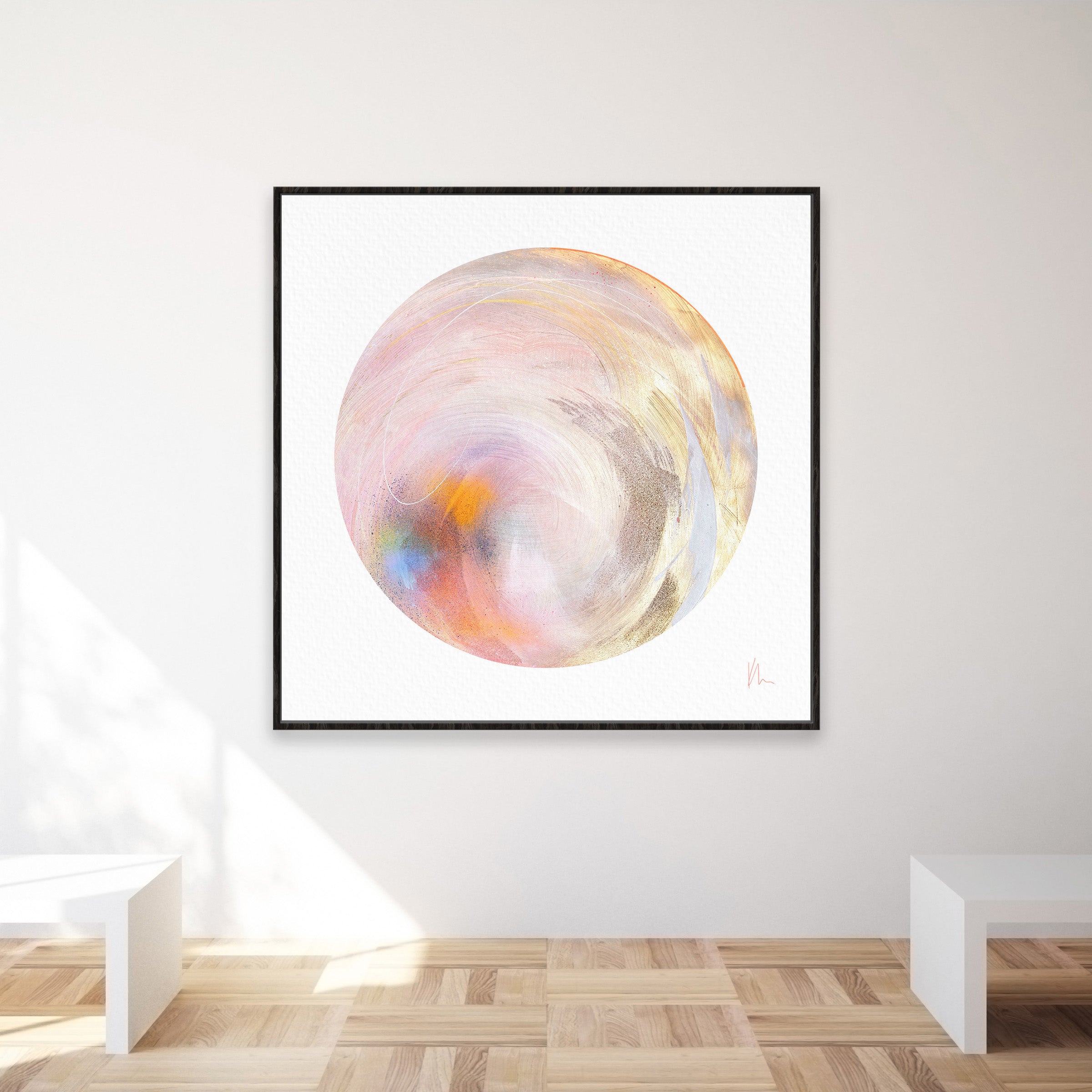 The artwork "Believe In Me" by Kate Mayer features an abstract depiction of a swirling sphere in pastel hues, accented with touches of metallic gold spray. Displayed prominently on a gallery wall above a wooden floor, its elegance is highlighted by white benches and delicate glimmers that evoke the sparkle of diamond dust.