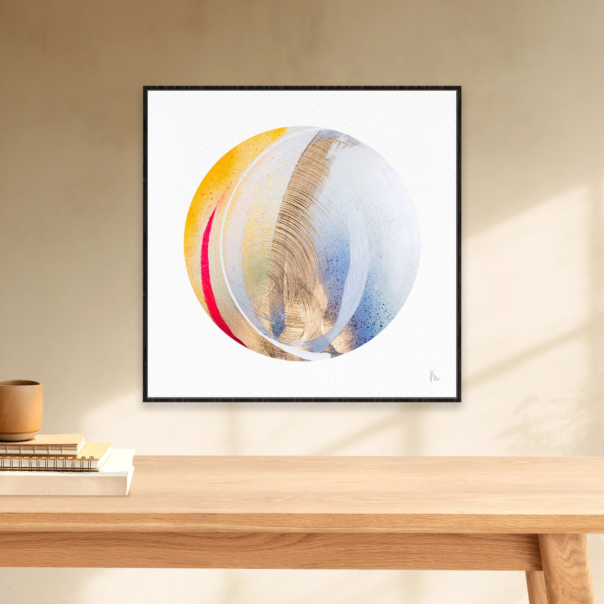 The "Be Sincere" artwork by Kate Mayer, showcasing abstract swirls of blue, yellow, and red on a white backdrop, exudes authenticity as it is framed and displayed elegantly on a beige wall.