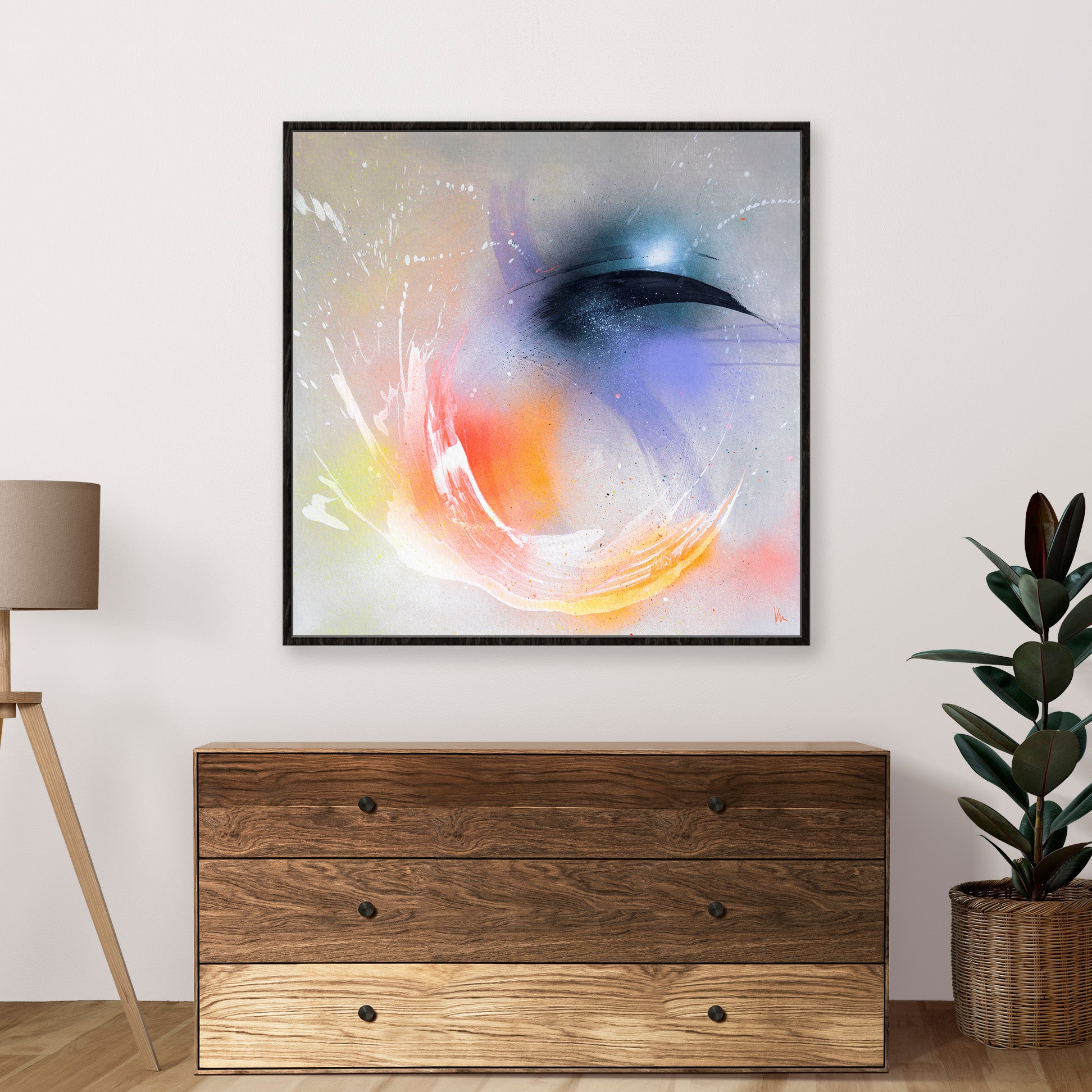 Eternal Vitality by Kate Mayer graces the wall above a wooden dresser, evoking the ethereal beauty of Iceland with its magical swirl of colors. A lush plant and a gleaming floor lamp stand gracefully beside it, enhancing this dreamy scene.