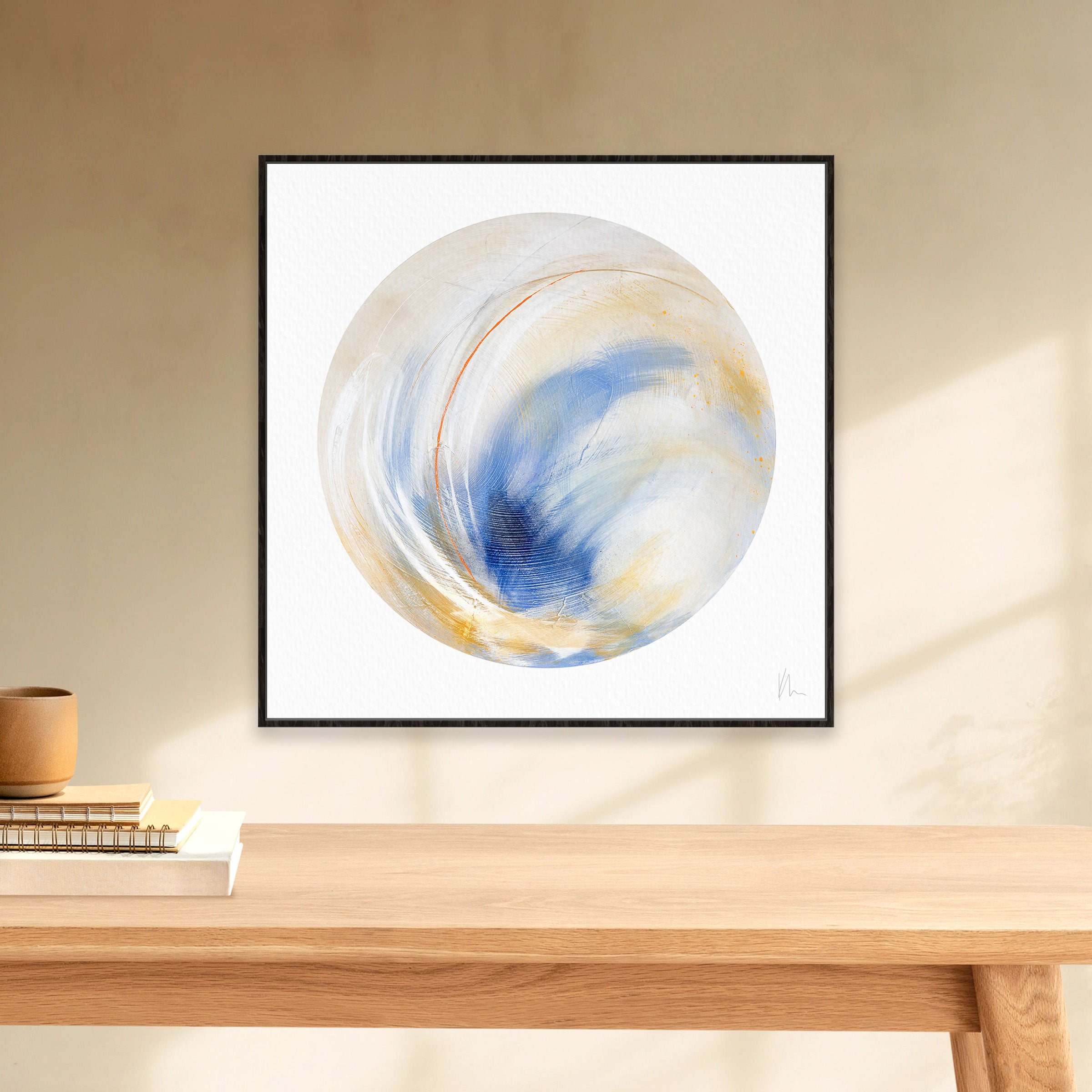 The "Go Your Own Way" abstract painting by Kate Mayer showcases swirling blue and gold tones, presenting a unique flair as it adorns a beige wall above a wooden table.
