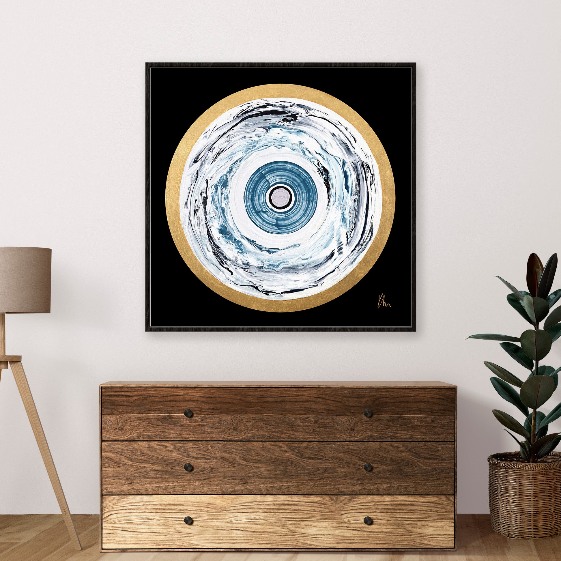 One Love by Kate Mayer is a square abstract painting with blue, gray, and white circular patterns set against a black background. This vibrant piece of art is perfect placed above a wooden dresser.