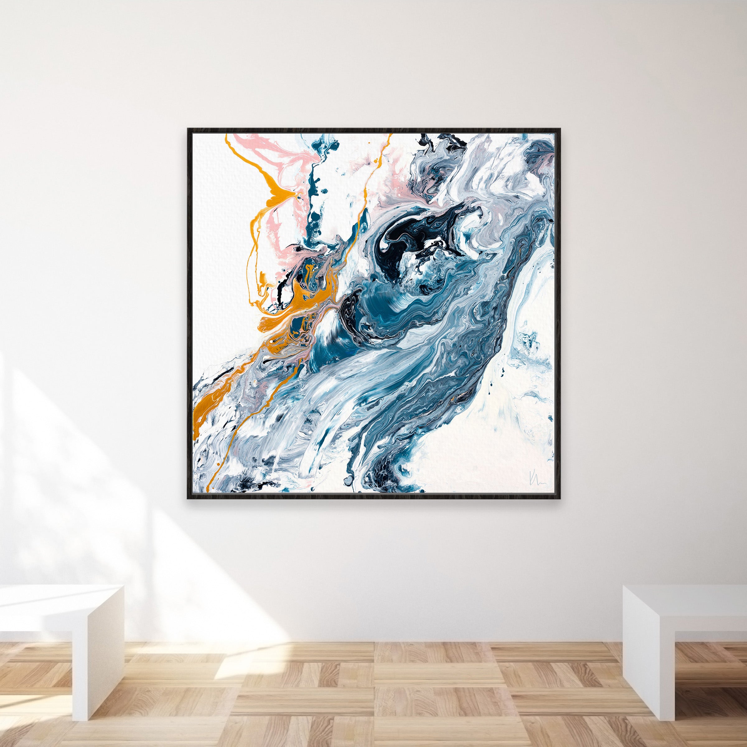 The "Undercurrent" by Kate Mayer features an abstract painting with swirling blue, white, and orange colors. It is beautifully framed by a black border, making it a striking piece on any wall. In this minimalistic room setting with a wooden floor, the artwork becomes the focal point of the décor.