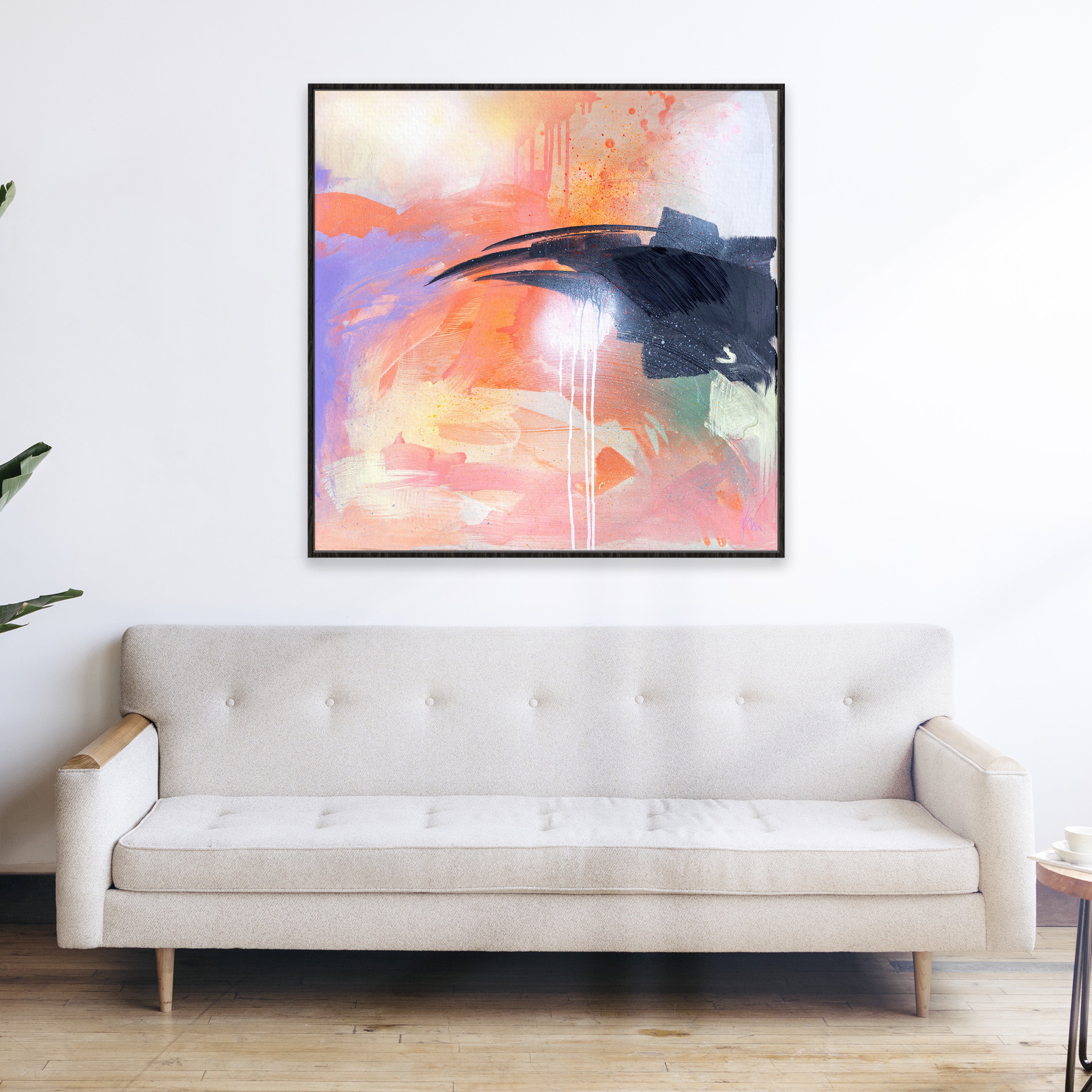 The painting, titled "Beneath The Surface" by Kate Mayer, featuring vibrant colors, is displayed above a beige sofa in a modern living room.