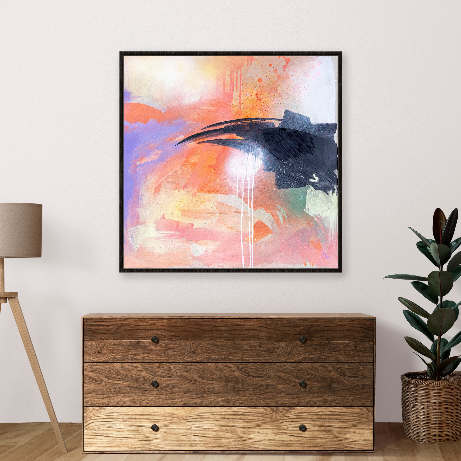 The artwork "Beneath The Surface" by Kate Mayer adds a splash of bold colors above a wooden dresser, complemented by a nearby potted plant and floor lamp.