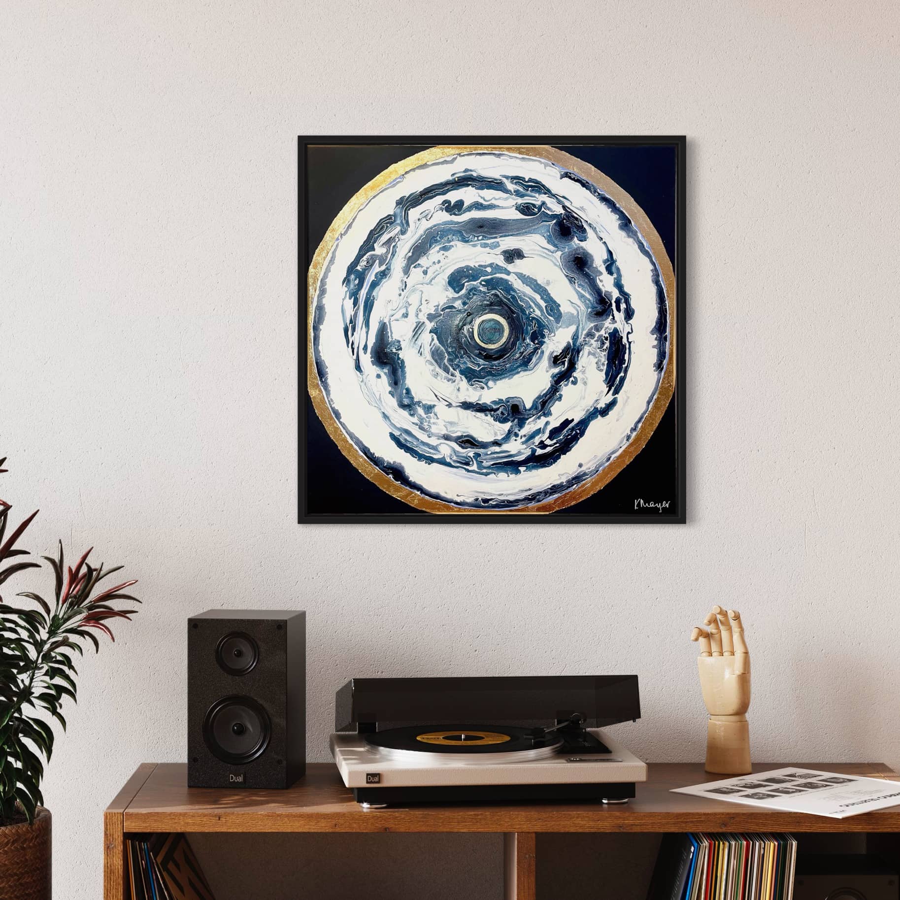 A painting titled "Oceans of Love" by Kate Mayer elegantly adorns the wall above a wooden shelf, which features a record player, speaker, and various decorative items.