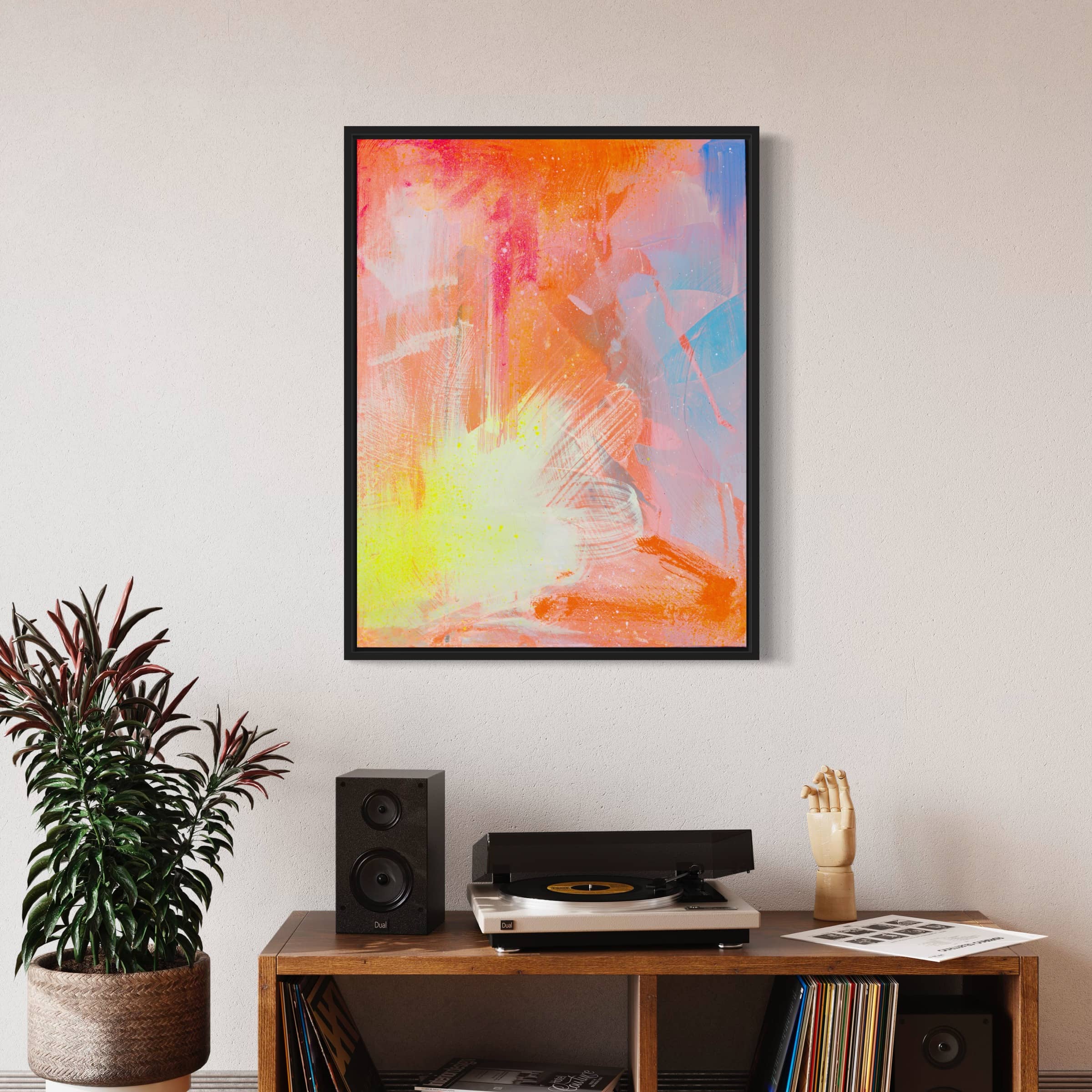 The "Dream Big" original painting by Kate Mayer, featuring vibrant acrylic and spray paint abstract art, adorns the wall above a shelf that holds a record player, speakers, a plant, and a decorative hand.