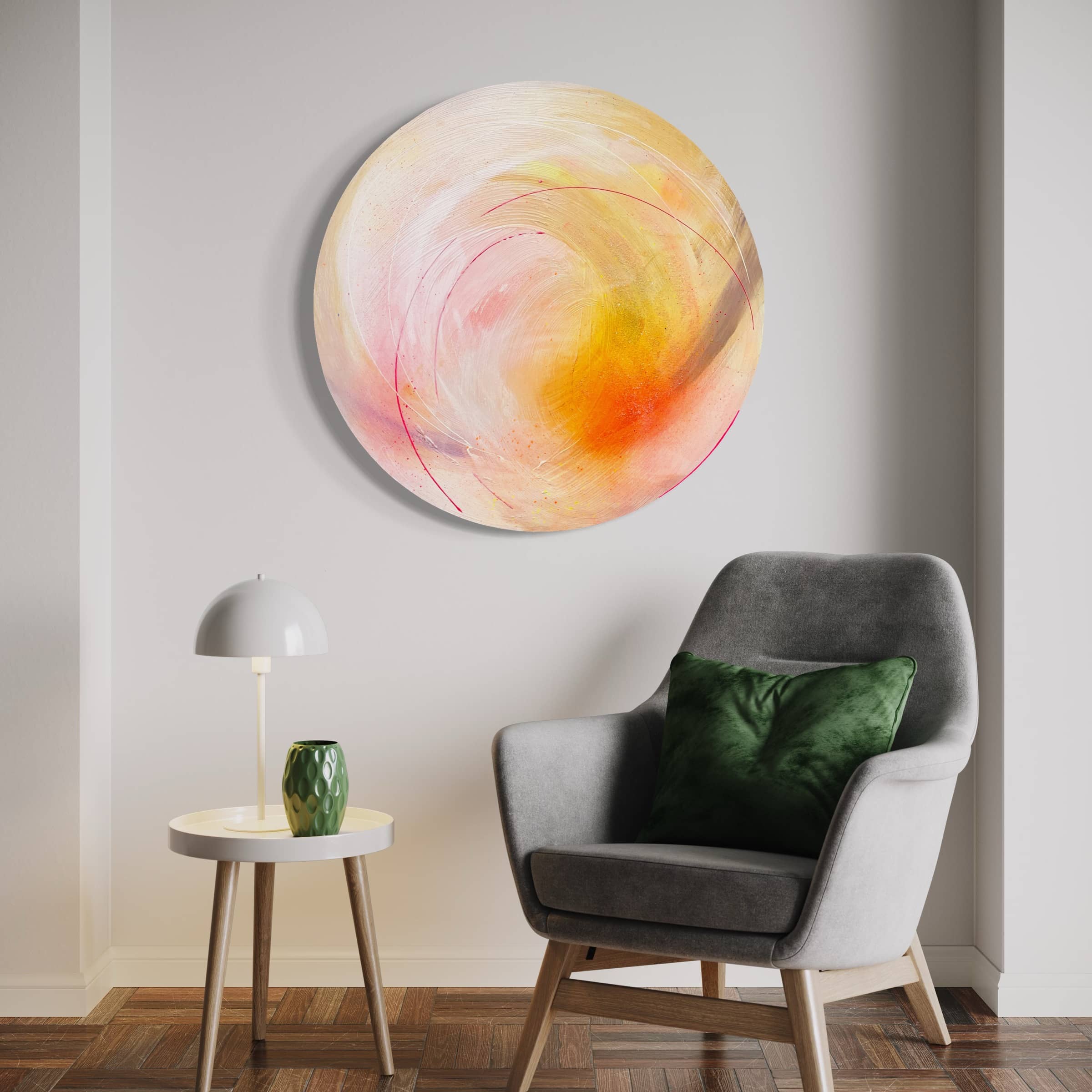 A cozy living room features a gray chair, a green pillow, and a small table. On the wall hangs "Happiness Is A Place Within," an original painting by Kate Mayer, infused with warm colors and highlighted by shimmering diamond dust.