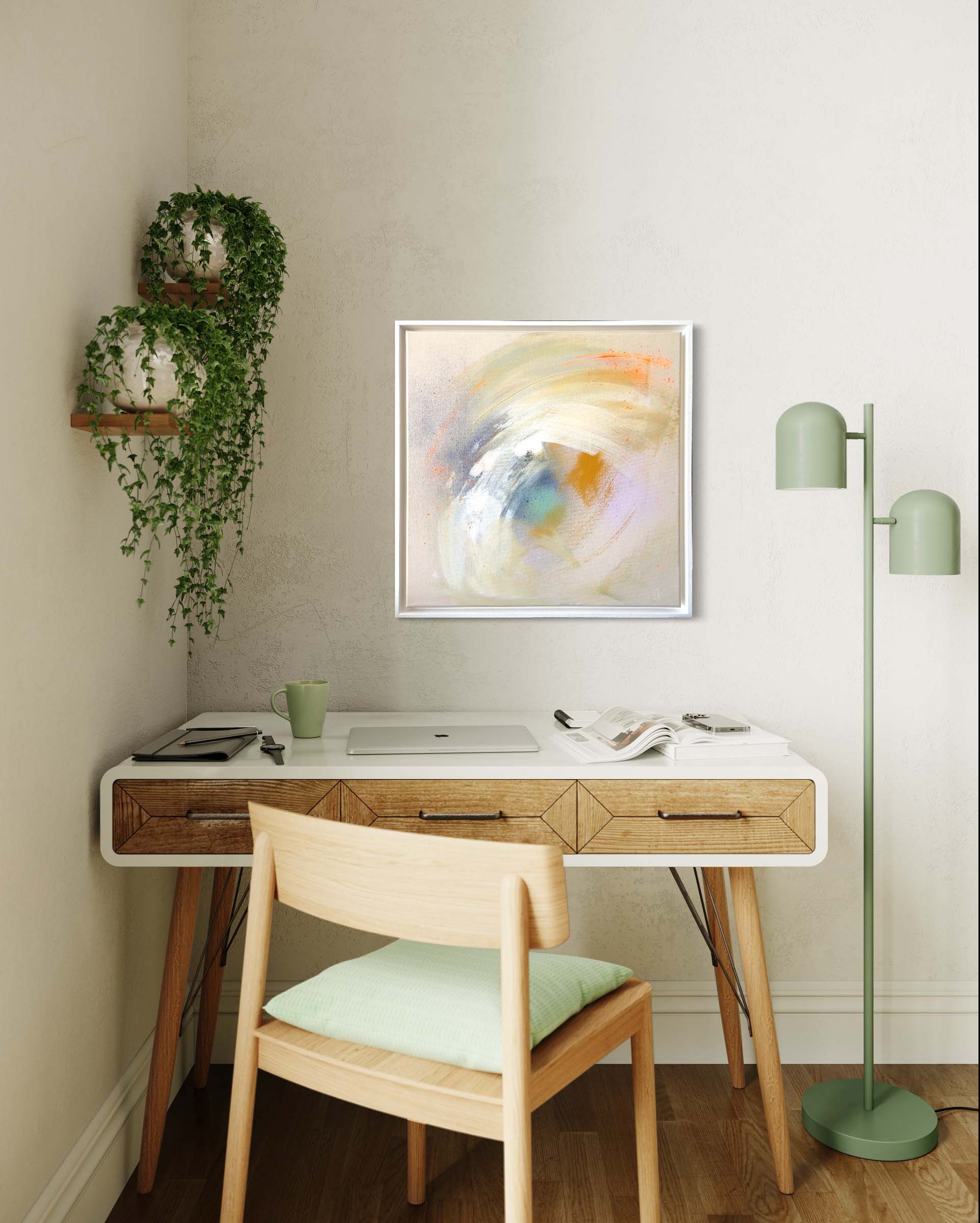 A cozy home workspace includes a wooden desk, chair, laptop, and a vibrant green lamp, with the "Make A Wish - Original Painting" by Kate Mayer in acrylic and spray paint gracing the wall above. Lush potted plants add a touch of greenery, creating an inviting atmosphere for creativity and focus.